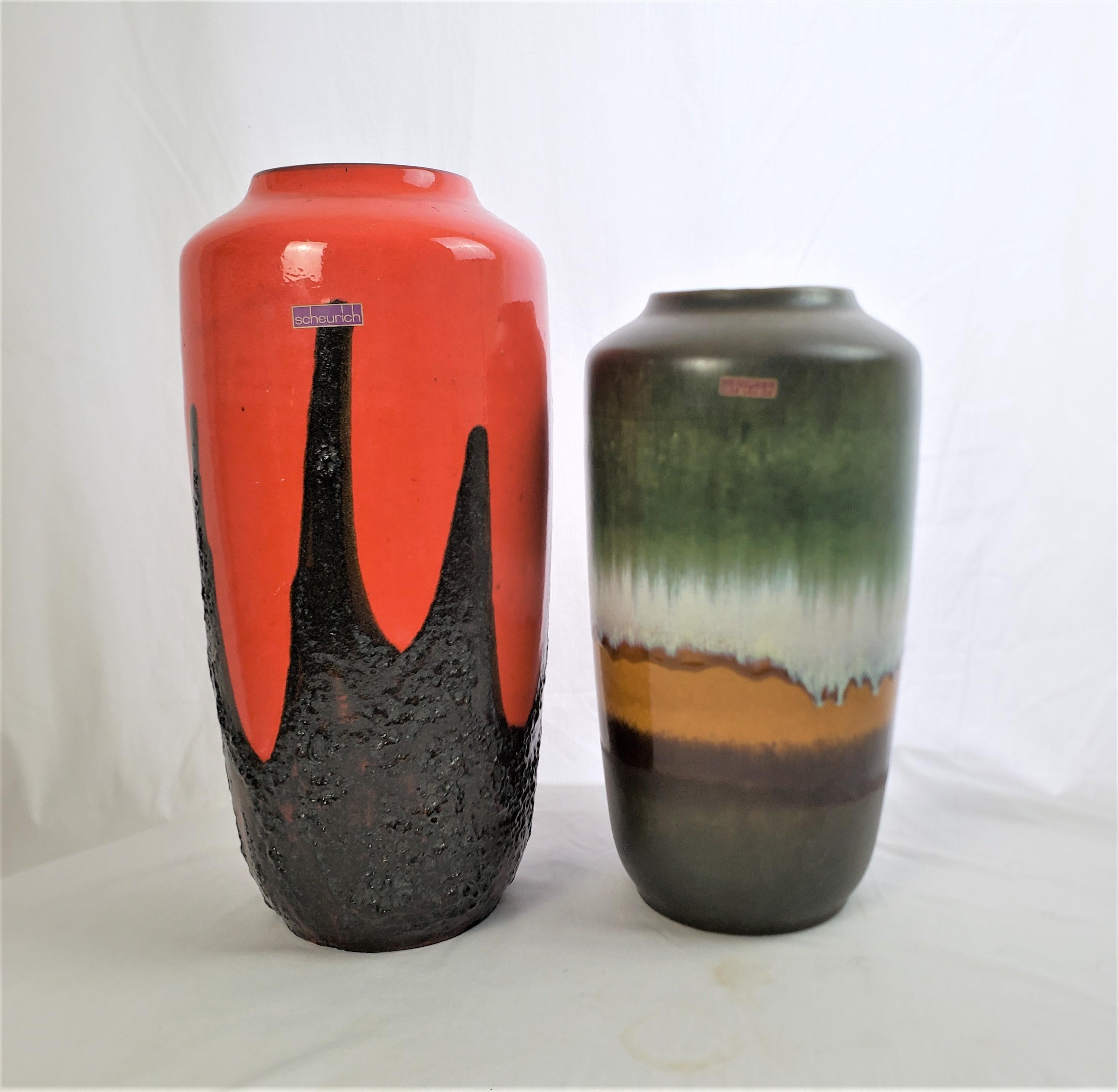 This pair of large vases were made by the Scheurich factory of West Germany in approximately 1965, and done in their signature Mid Century Modern style. The vases are composed of molded ceramic, with a hand-painted glaze. The larger vase is done in