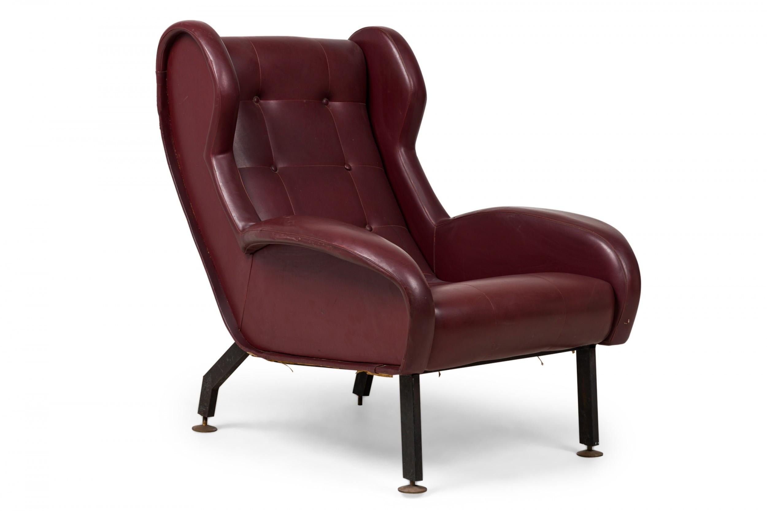 Pair of Mid-Century Norwegian (1970s) wing back armchairs with low side arms upholstered in button tufted deep burgundy red leather and standing on flat bar metal legs with 4 adjustable disc feet. (WESTNOFA) (PRICED AS Pair)

Wear & tear on