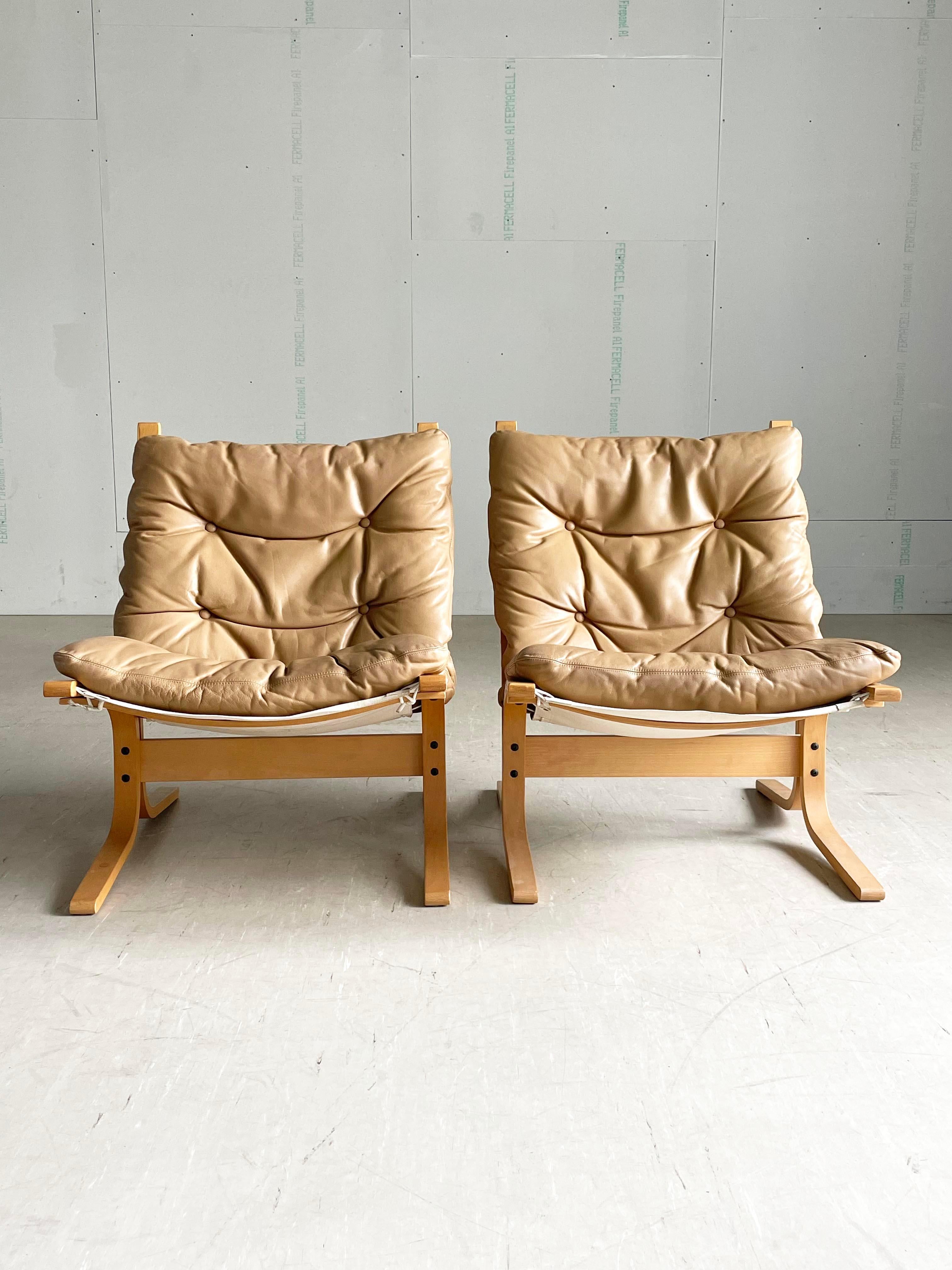 Pair of Westnova Ingmar Relling 'Siesta' Lounge Chairs Two identical chairs with low back bent plywood bases with sling leather seat pads. 
Designed by Ingmar Relling, 1965. Produced by Westnova, Norway. 1980's productions in good condition with