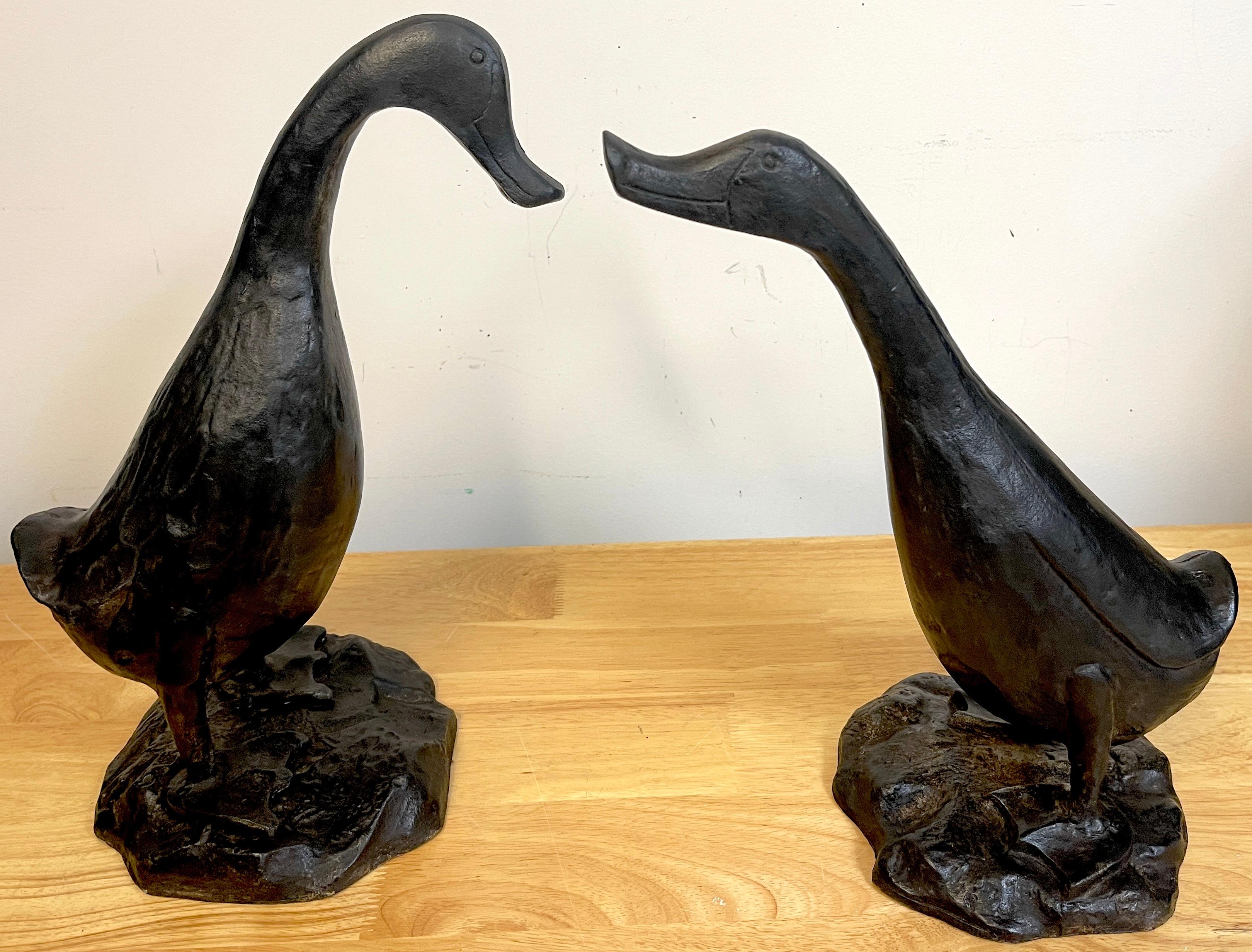 Pair of Whimsical Art Deco Garden Sculptures of Ducks, cast in muted expressiveness, one is slightly larger, both standing on rock work bases. Unsigned, Can be used outdoors or indoors 
Measures: Larger 15' H x 11