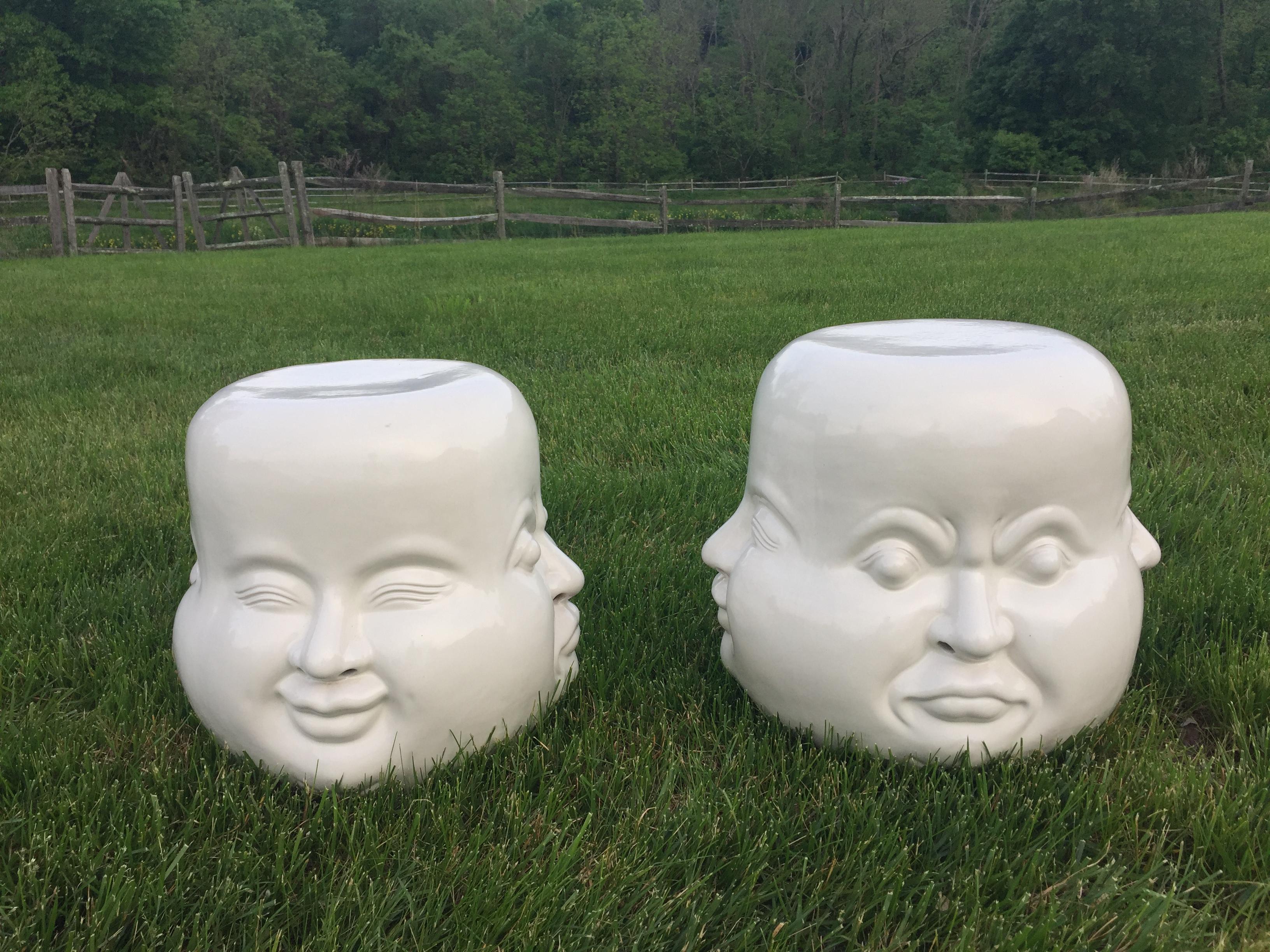 Two fabulous white ceramic round garden seat end tables that have 4 different facial expressions, one per side. An exact matched pair. The round surface top is 13 inches in diameter.