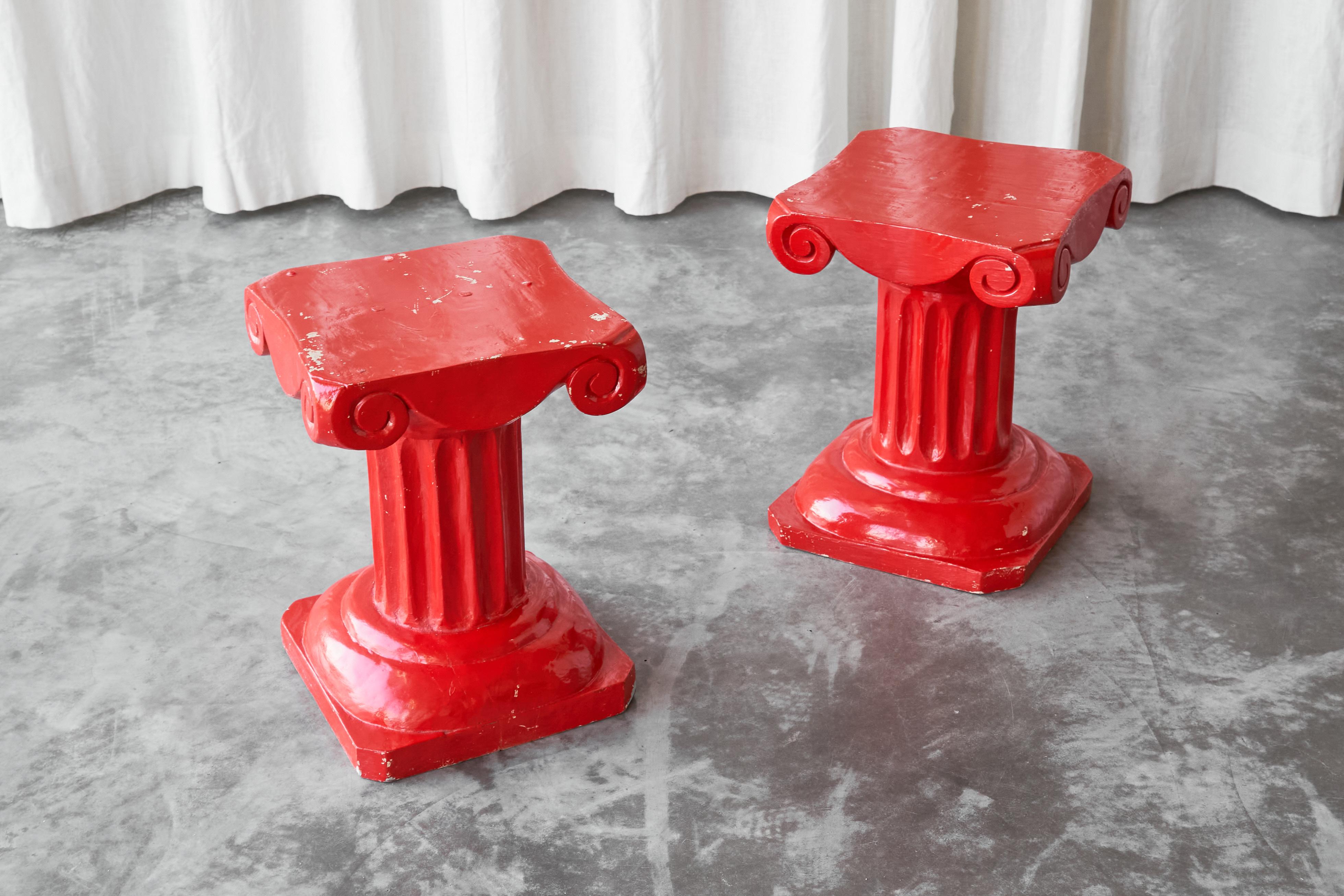 This is a fun pair of hand carved column stools or side tables in solid wood, made by an artisan craftsman in the middle of the 20th century.

Quirky and one-off, these red lacquered column shaped stools or side tables are no doubt a colorful