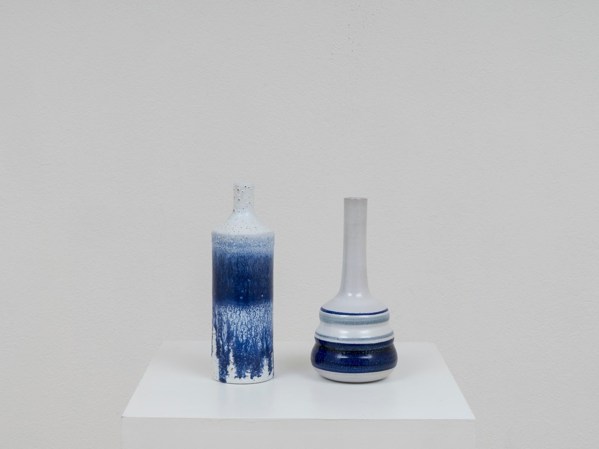 Paire de vases bouteilles en céramique de Pino Castagna, au décor bleu et blanc à forte connotation méditerranéenne. Dégoulinades d'émail et finitions tactiles sur une bouteille. Cette pièce a été fabriquée dans le laboratoire de l'artiste à