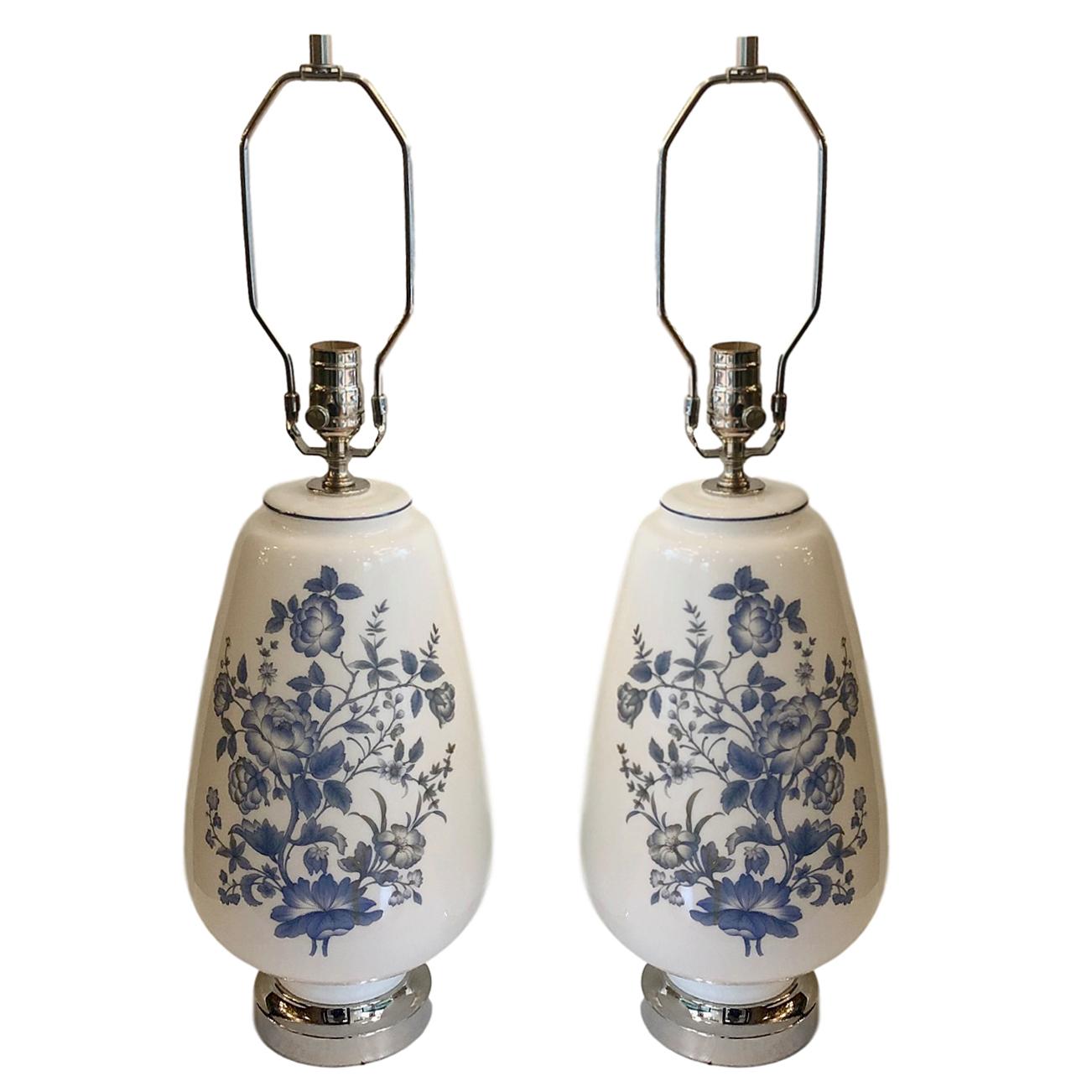 A pair of large circa 1940s French white opaline glass lamps with blue floral decoration.

Measurements:
Height of body: 17