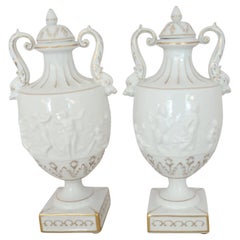 Pair of White and Gilt Capodimonte Porcelain Urns with Lids and Putti Decoration