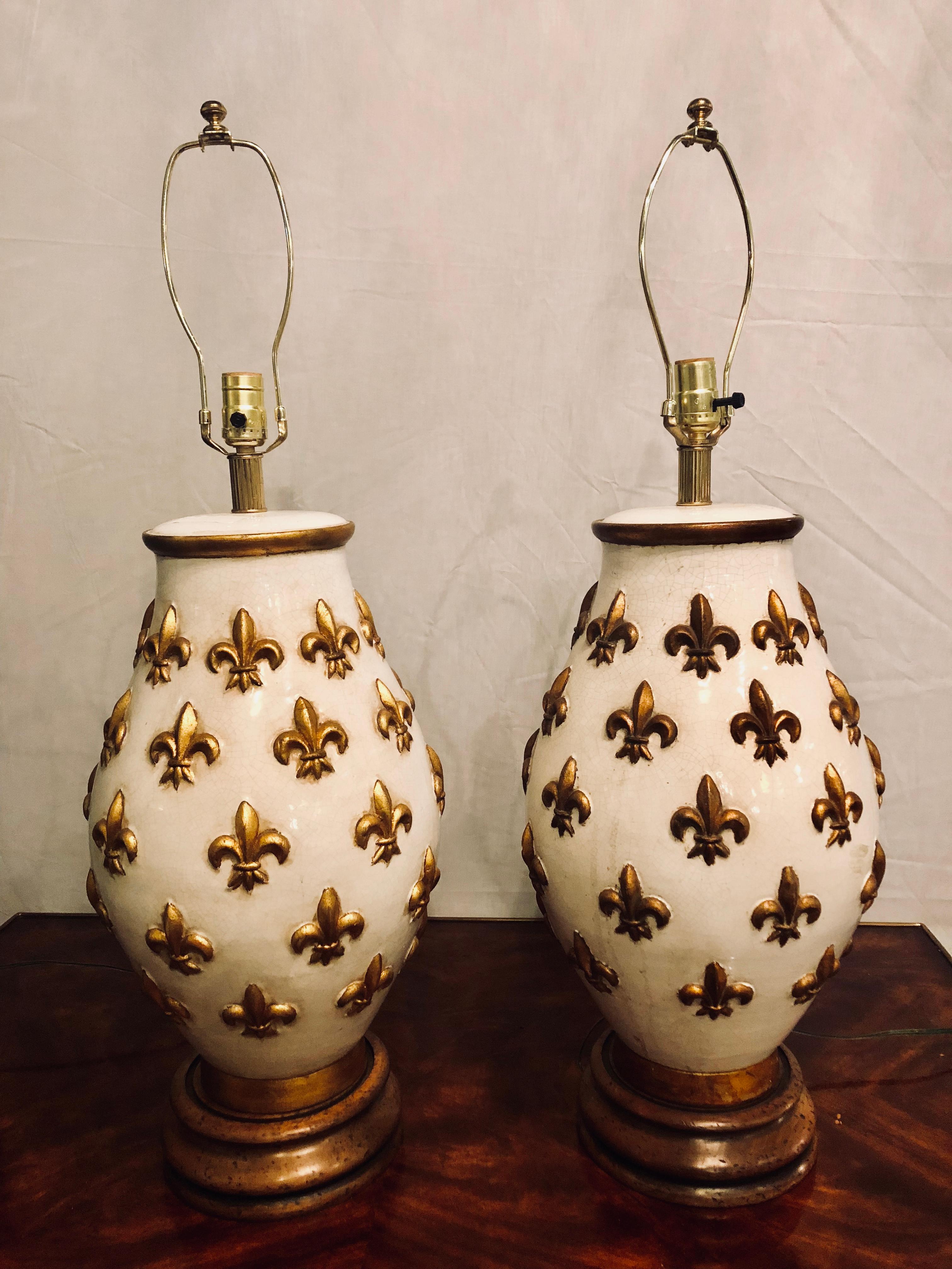 A pair of white and gilt porcelain bulbous shaped table lamps on wooden bases.