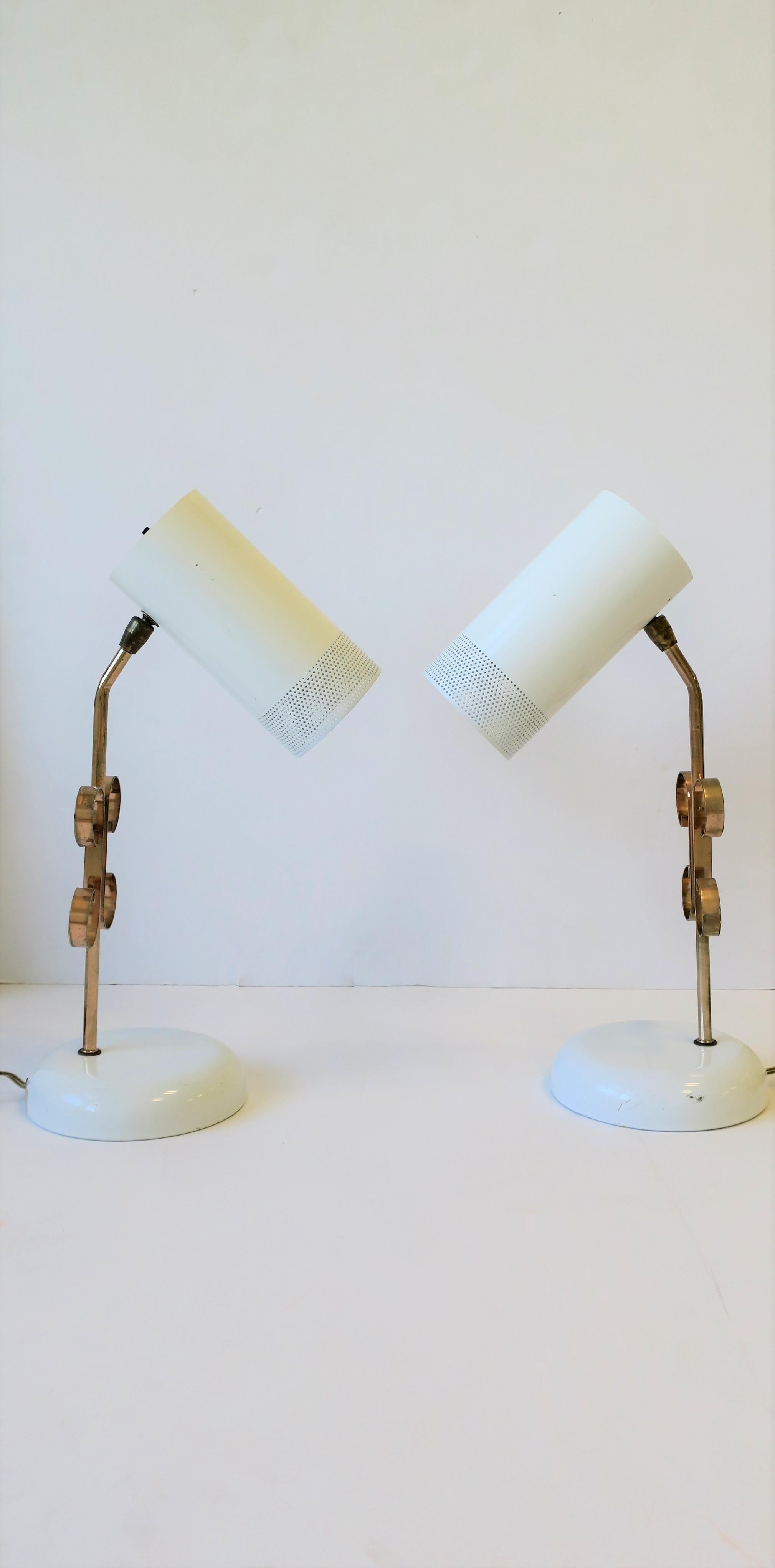A pair of Modern white and rose-pink metal table lamps, circa early 1970s. A chic and rare pair of 1970s Modern white enameled metal table lamps; Pair are white metal shades with perforated detail that adjust up/down and side to side as demonstrated
