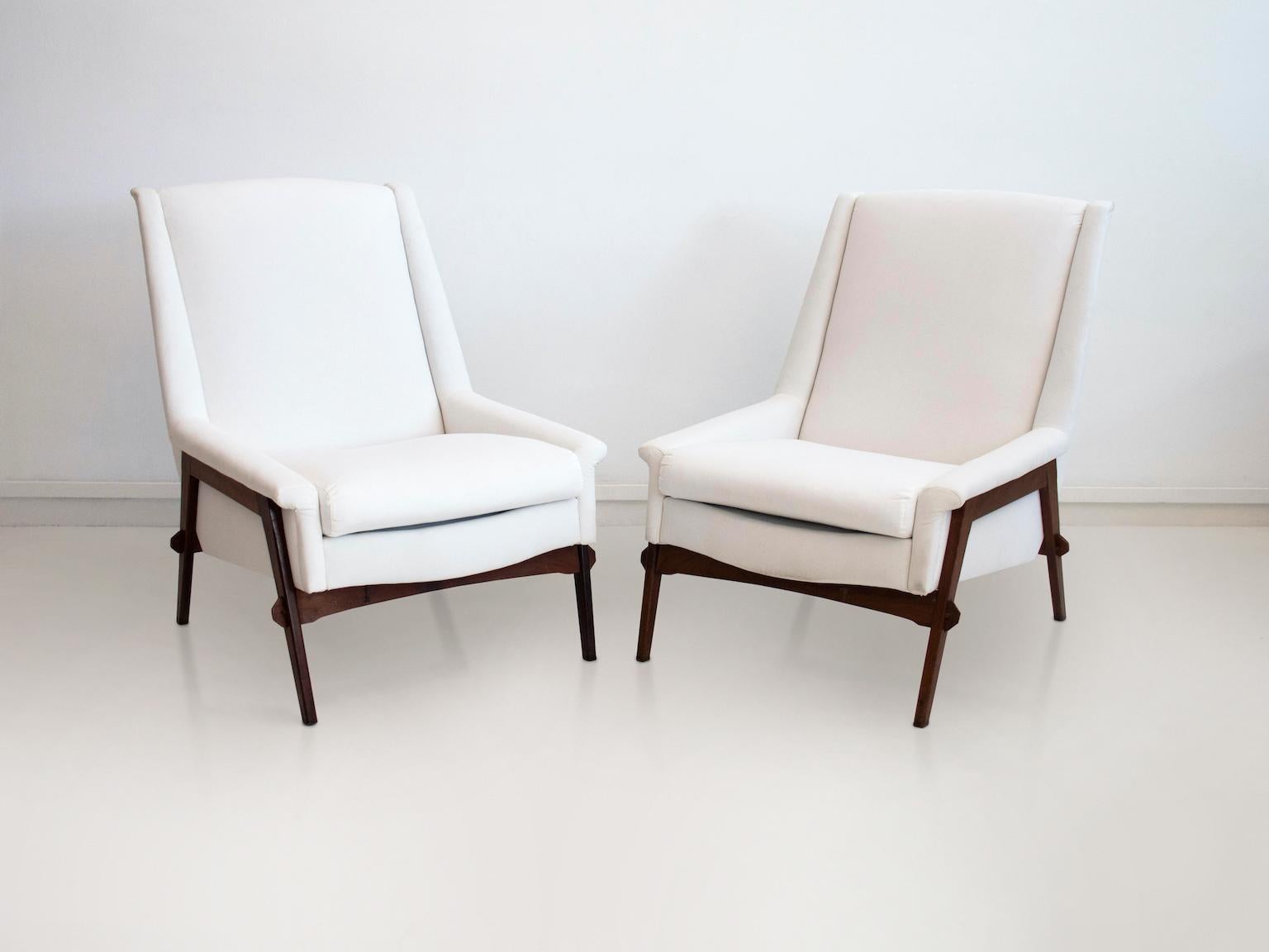 Pair of armchairs, made in Italy, circa 1950s. Structure in stained oakwood, upholstered cushions covered in white fabric. Good vintage condition, minor stains on upholstery.