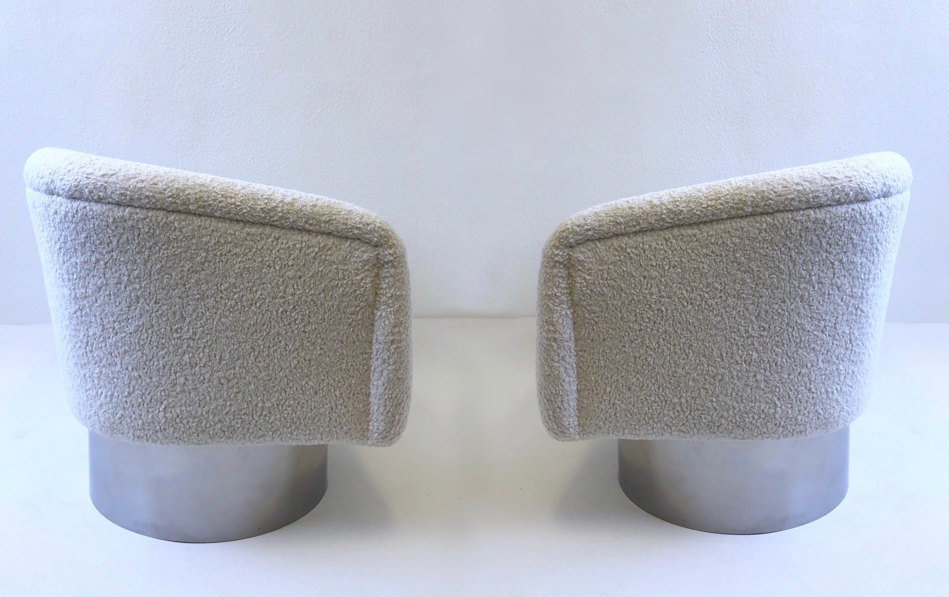 Glamorous 1980’s pair of swivel lounge chairs designed by Leon Rosen for Pace. 
Newly recovered with a soft white boucle fabric the bases are in original condition, so they show minor wear consistent with age. 
Measurements: 28” wide, 30” deep,