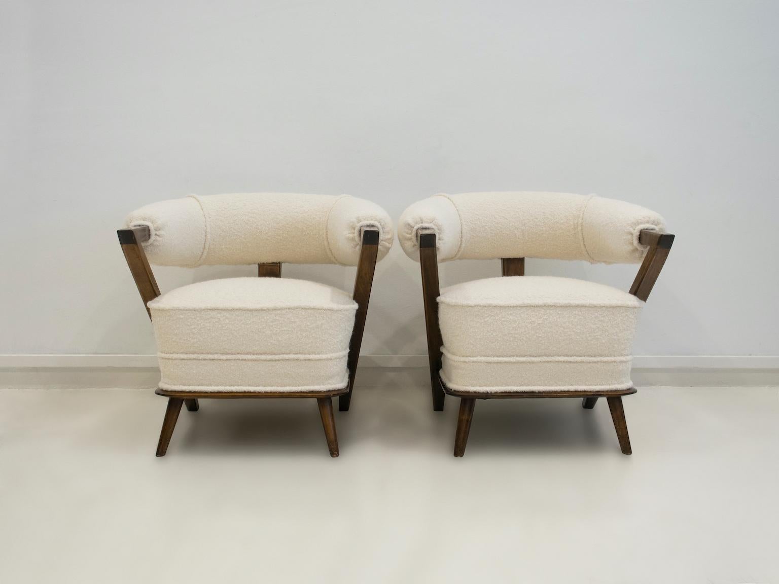 Paar elegante weiße Wannensessel im Art-déco-Stil, hergestellt in Italien in den 1960er Jahren. Gestell aus dunkel gebeiztem Holz und neue Polsterung aus weißem Bouclé-Stoff. Leichte Abnutzung am Holzteil der Armlehnen.