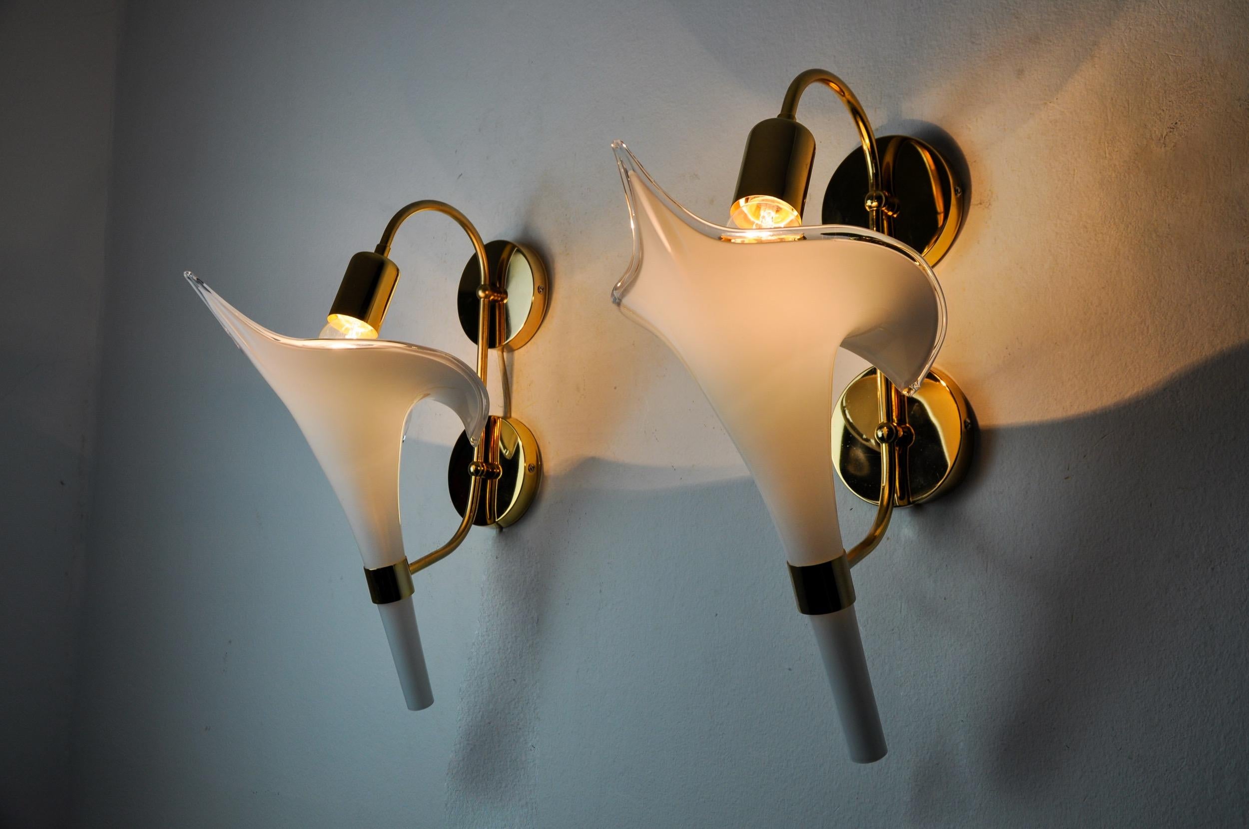 Superb and rare pair of fleur de lys wall lamps in murano glass, designed and produced in italy in the 1970s. Gilded metal structure composed of a white cut crystal in the shape of a fleur-de-lys, made by italian master glassmakers. Rare design