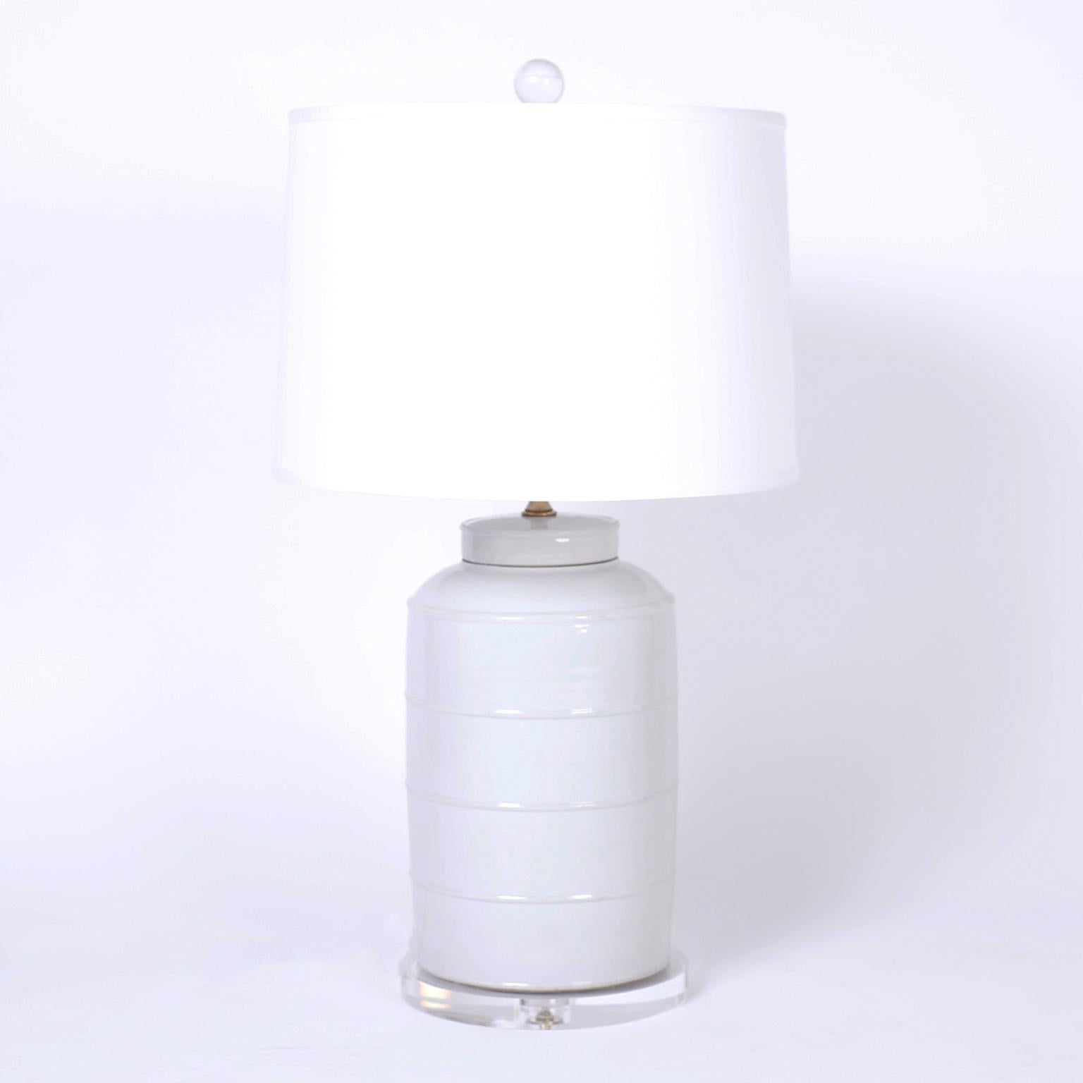 Pair of Chinese table lamps with classic form and subtle pale celadon color, presented on Lucite bases.