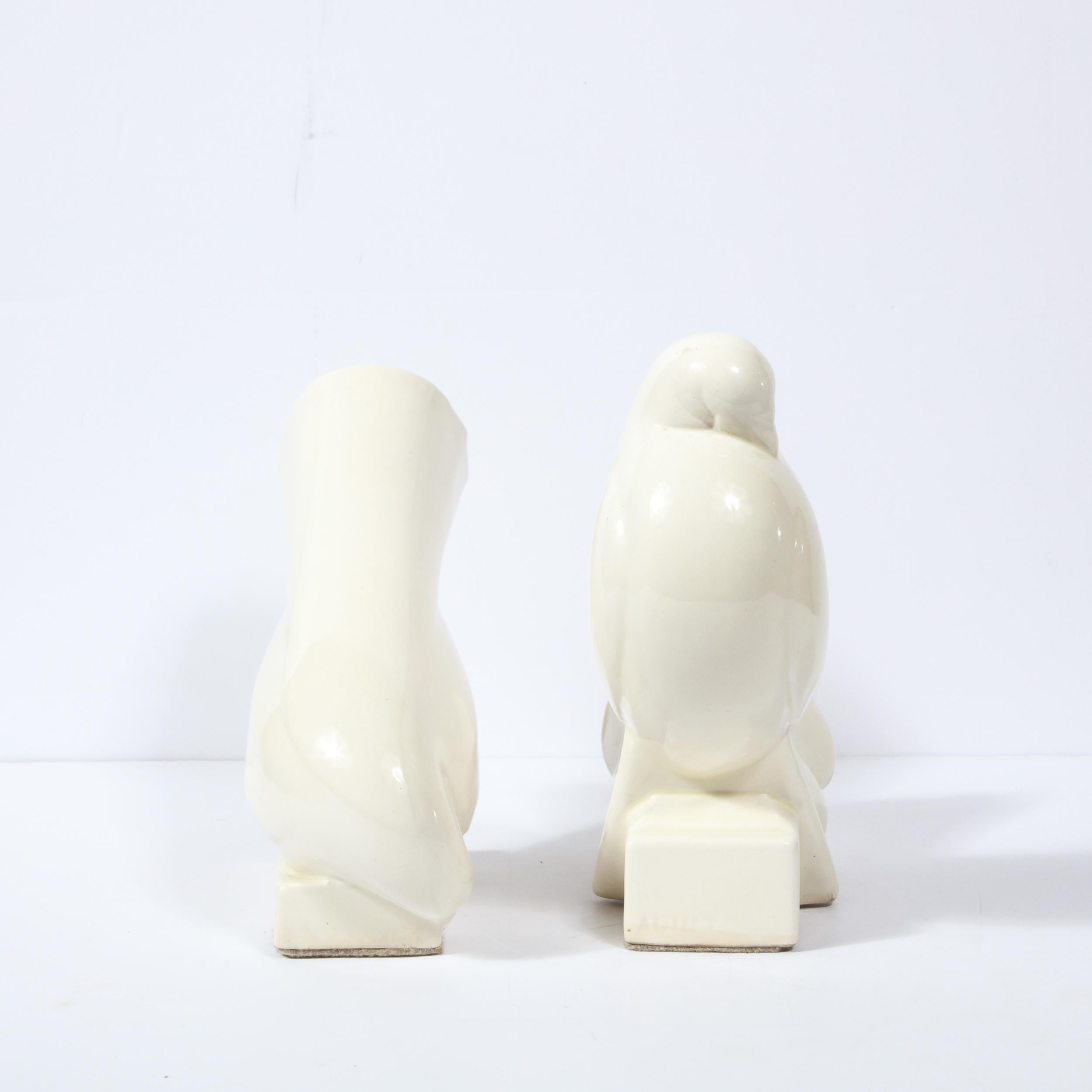 This stunning pair of Art Deco white ceramic dove sculptures were realized by Jacques Adnet- one of the most celebrated and influential designers of the Art Deco Era- in France circa 1940. They offer modernist stylized forms of doves- a leitmotif in