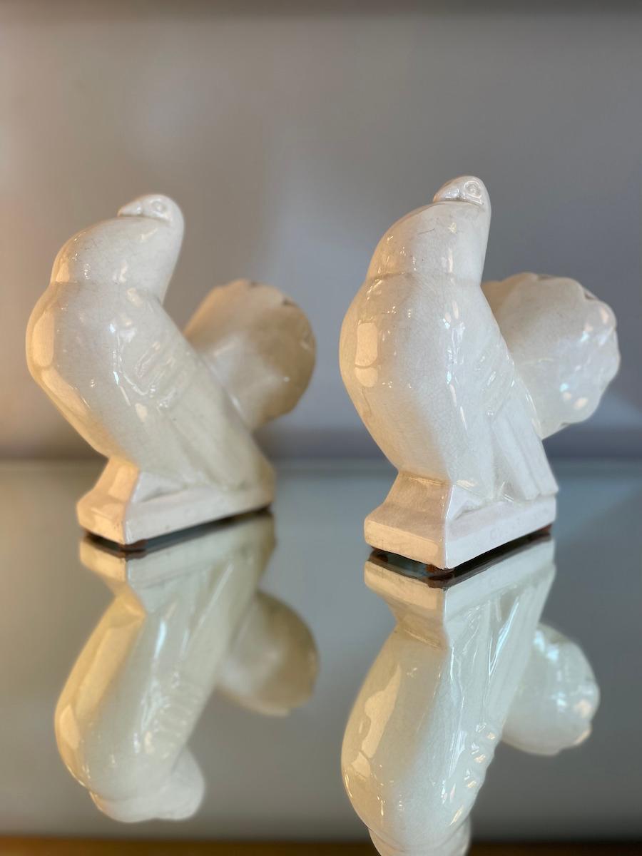Sculpture of two white ceramic doves from the 1940s. The doves are depicted at rest, with wide, flowing tails—features typical of the Deco style. The distinctive craquelé finish adds a refined and sophisticated touch to the ceramics.

Dimensions of