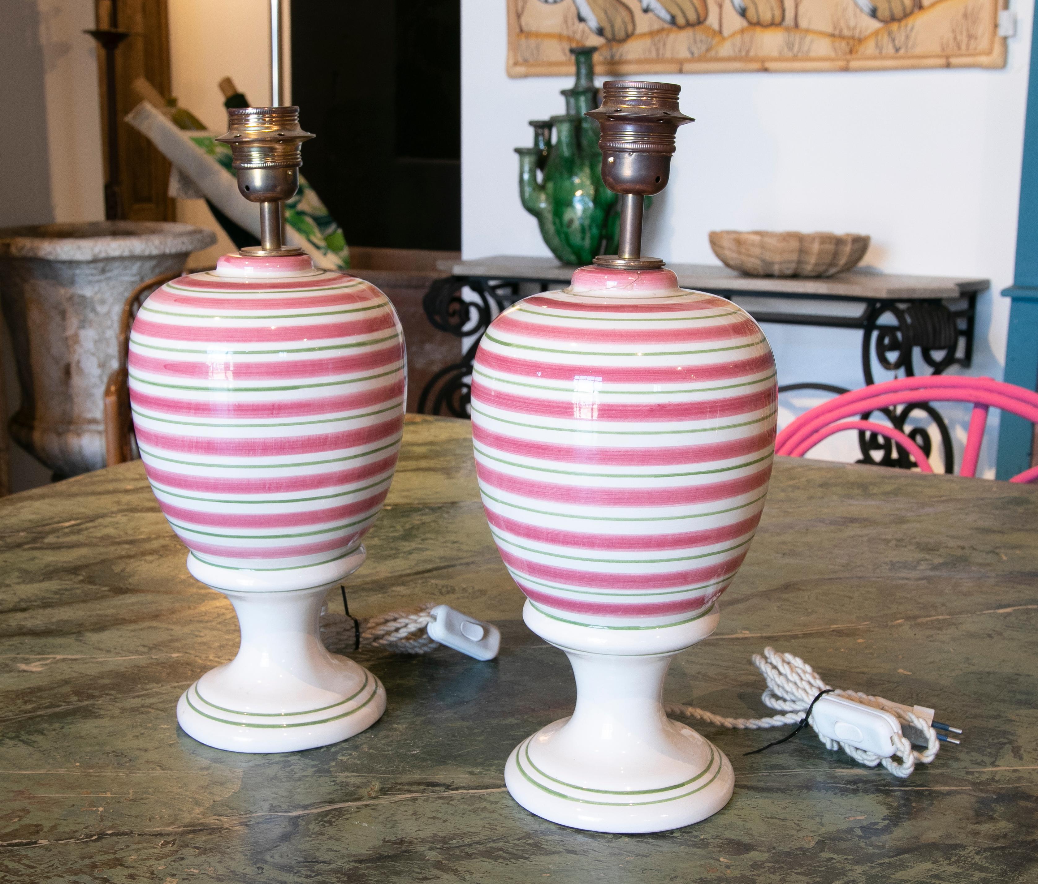 Pair of white ceramic table lamps with handpainted red and green stripes.