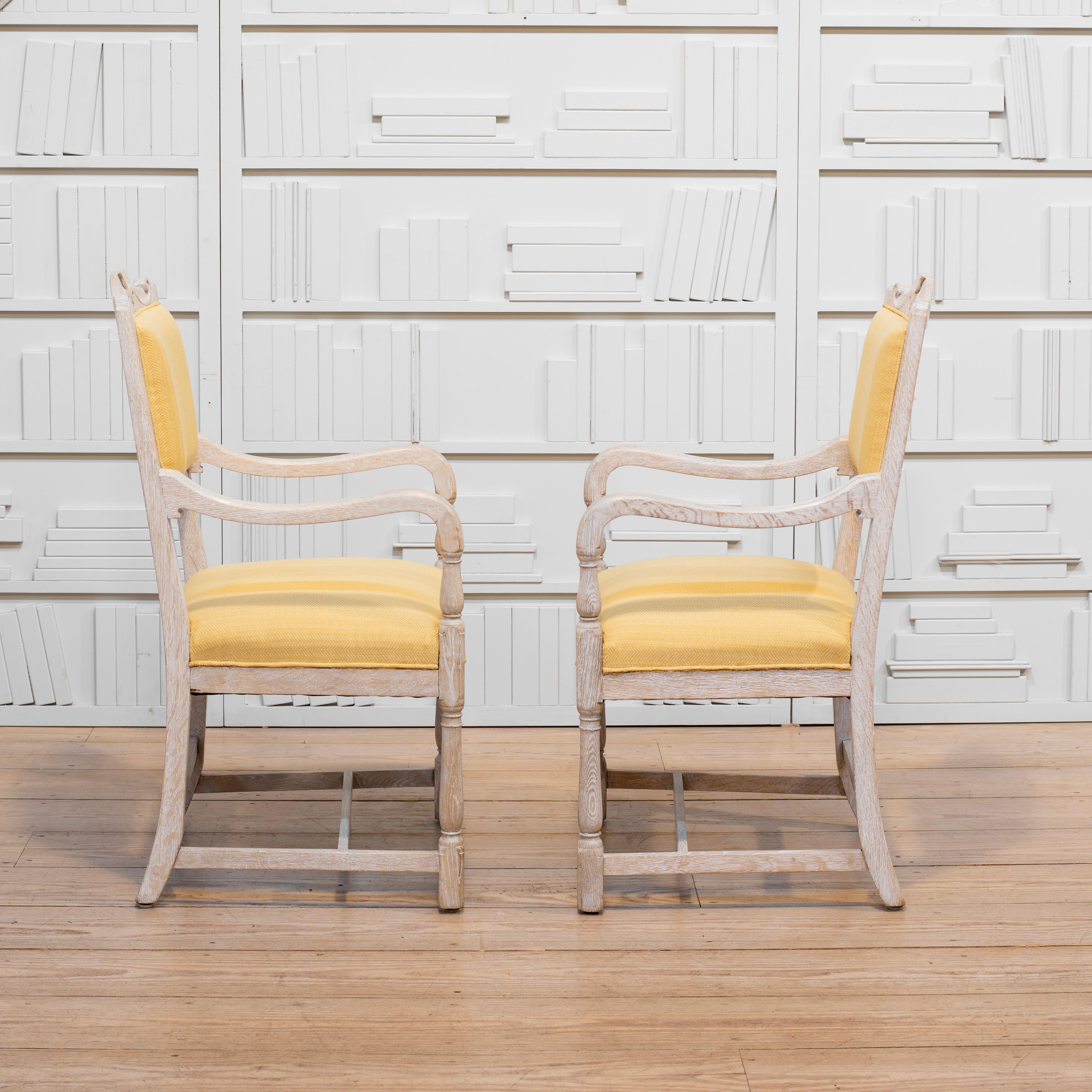 Paire de fauteuils français avec des cadres en chêne blanchi et cérusé, tapissés de chevrons jaunes. Les accoudoirs sont en forme et des tulipes stylisées sont sculptées sur le dessus de chaque dossier. Pieds avant tournés et pieds arrière façonnés.