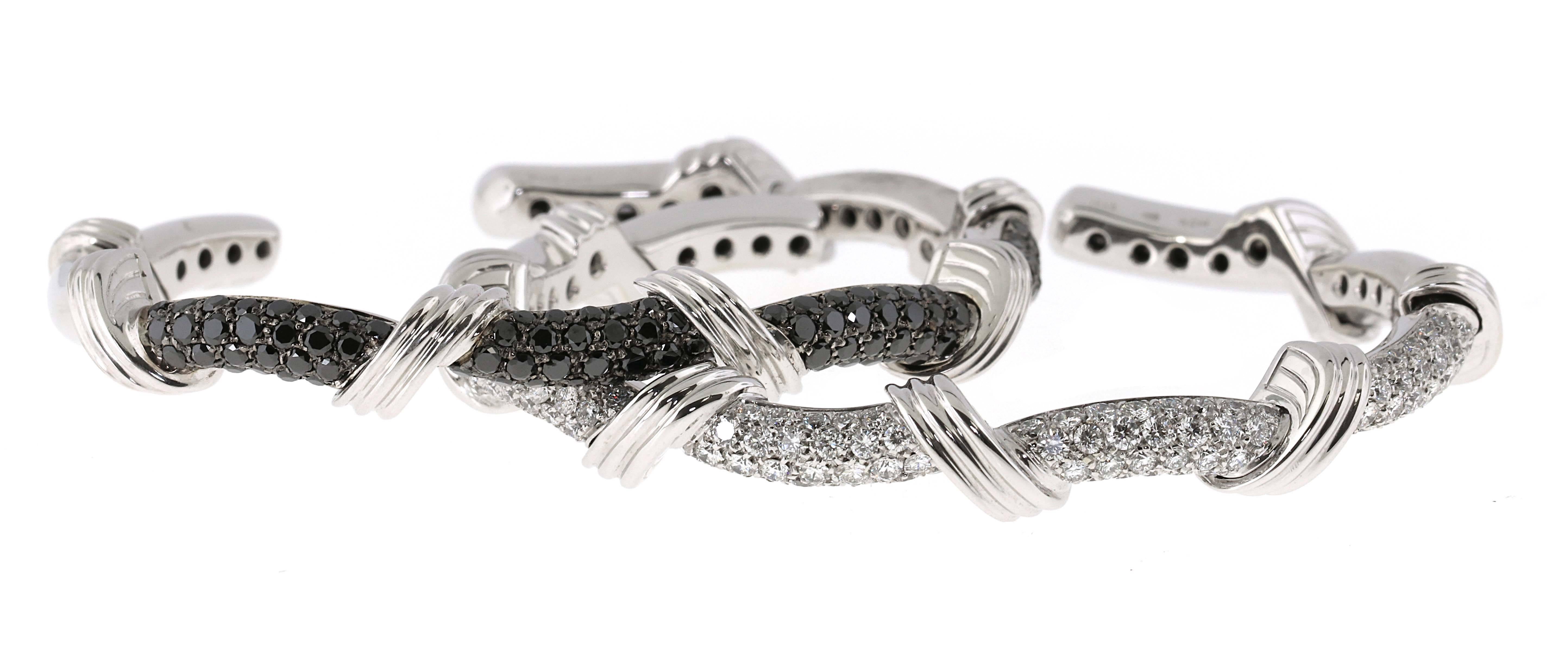 Fantastic looking pair of White and Black diamond bangles set in 18kt white gold. These are not 14kt white gold but rather 18kt making them a sturdier higher quality pair of bangles. Each bangle contains over 100 diamonds individually set to create