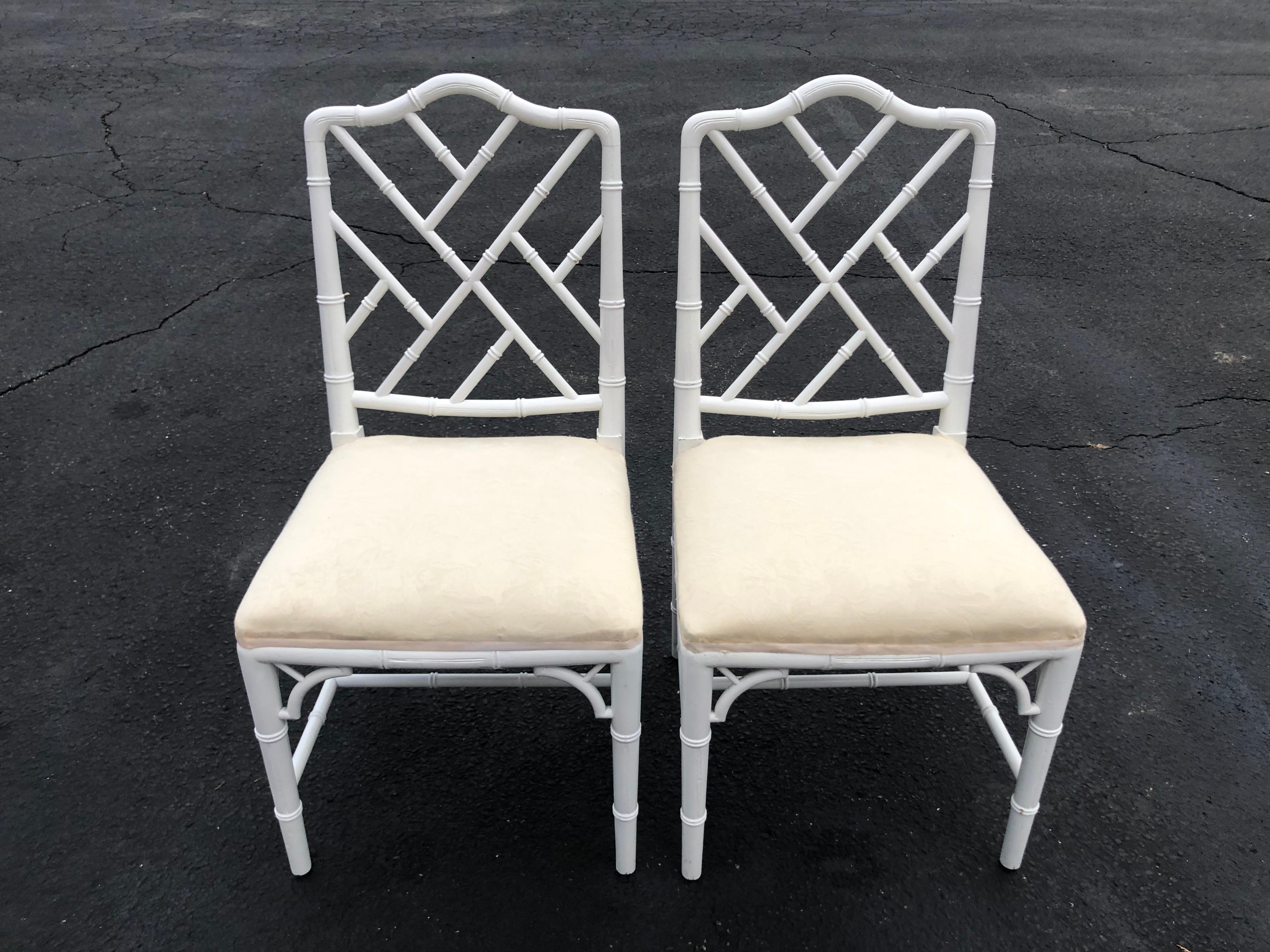Pair of white faux bamboo chinoiserie chairs. Simple off white upholstered seat. Classic coastal in-style seating.
 
