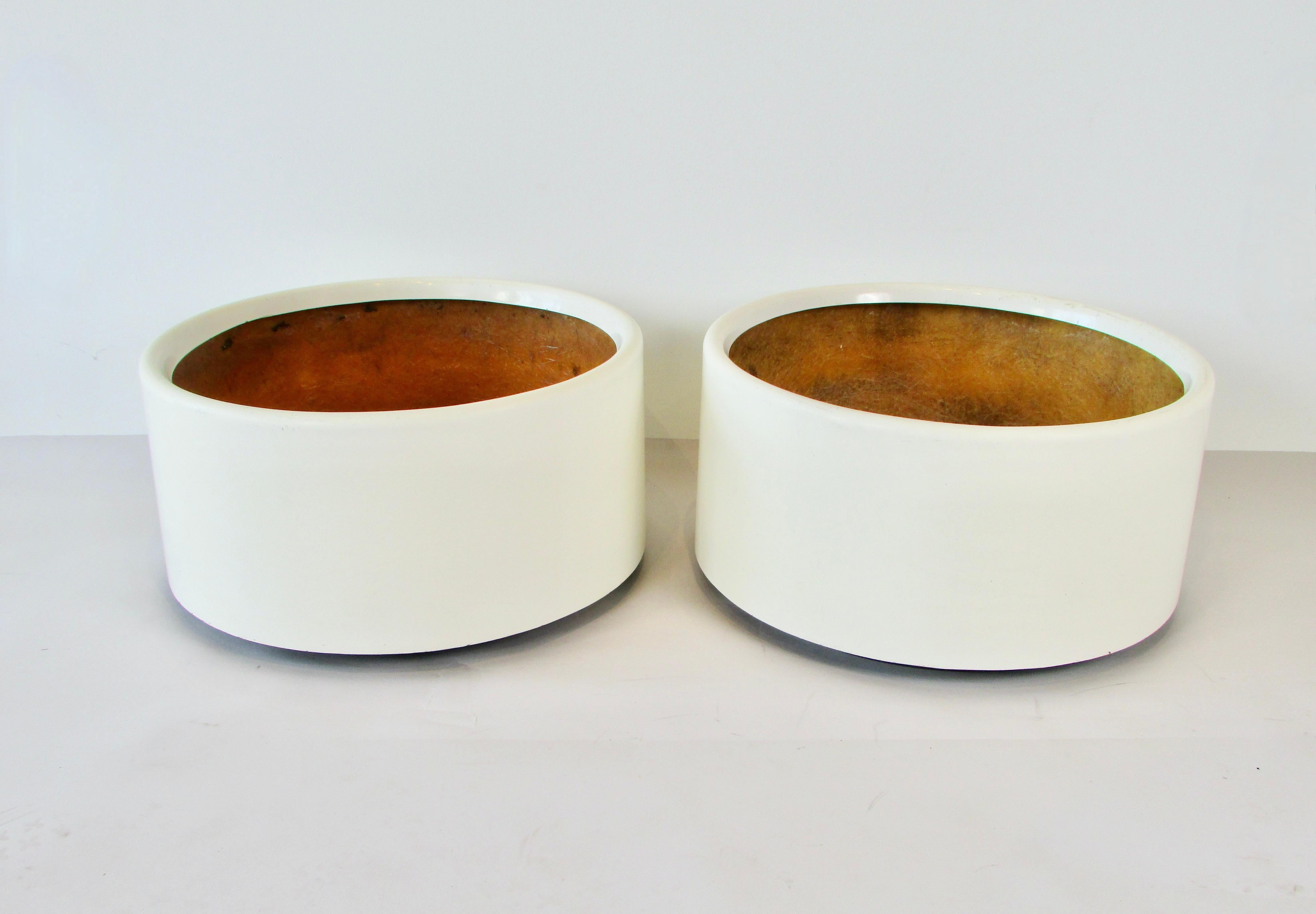 Unique round cylinder form planter pots. In appearance very much like an Architectural Pottery piece . These are molded in fiberglass much the same way as a boat. White gel coat over  sturdy fiberglass matte. They do show minor scratches and wear.