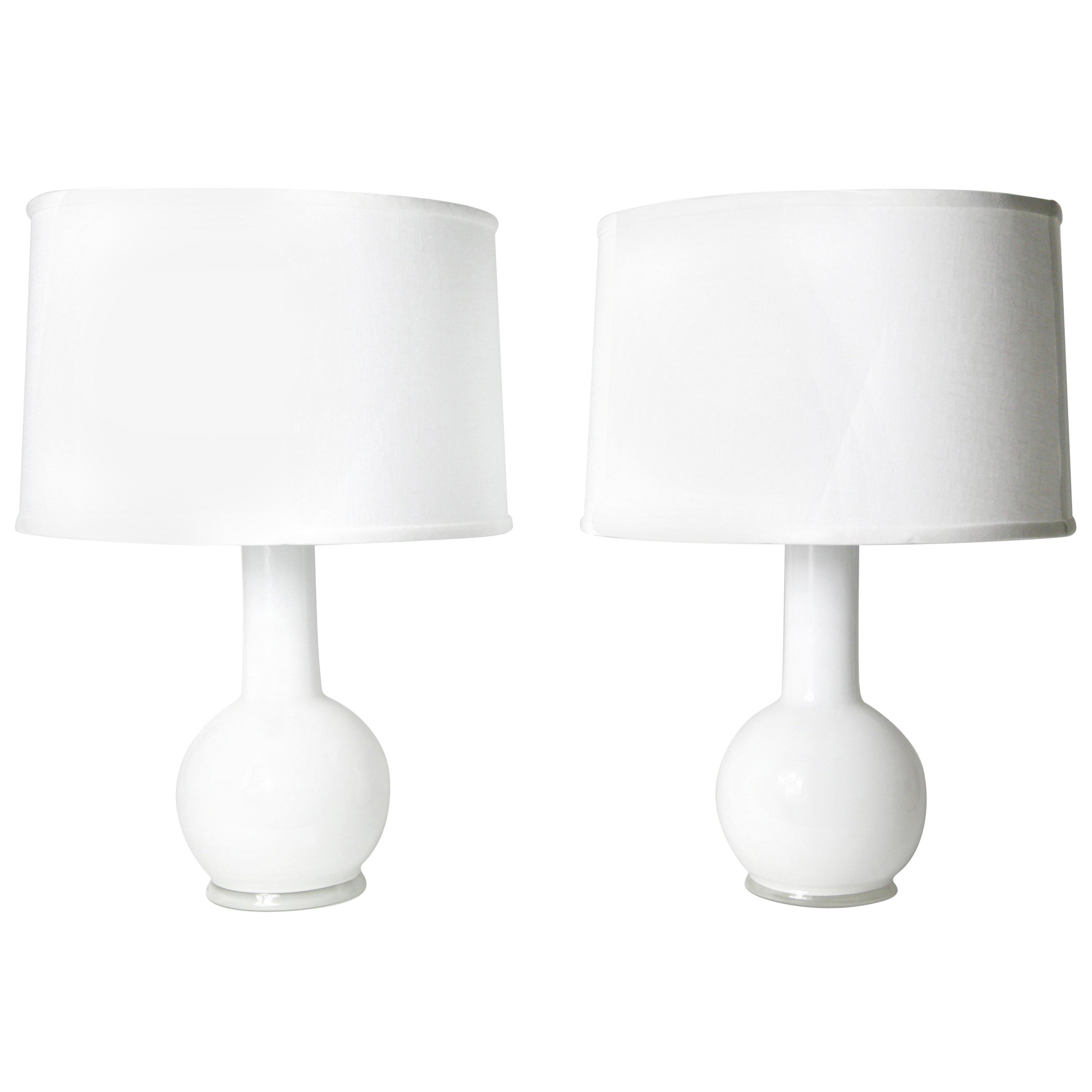 Pair of white dual layered glass lamps by Luxus lighting, Sweden, 1980
Beautiful round white glass bases encased in an outer layer of clear glass great size and body in a timeless manner.

Rewired for the US.
Shades not included.