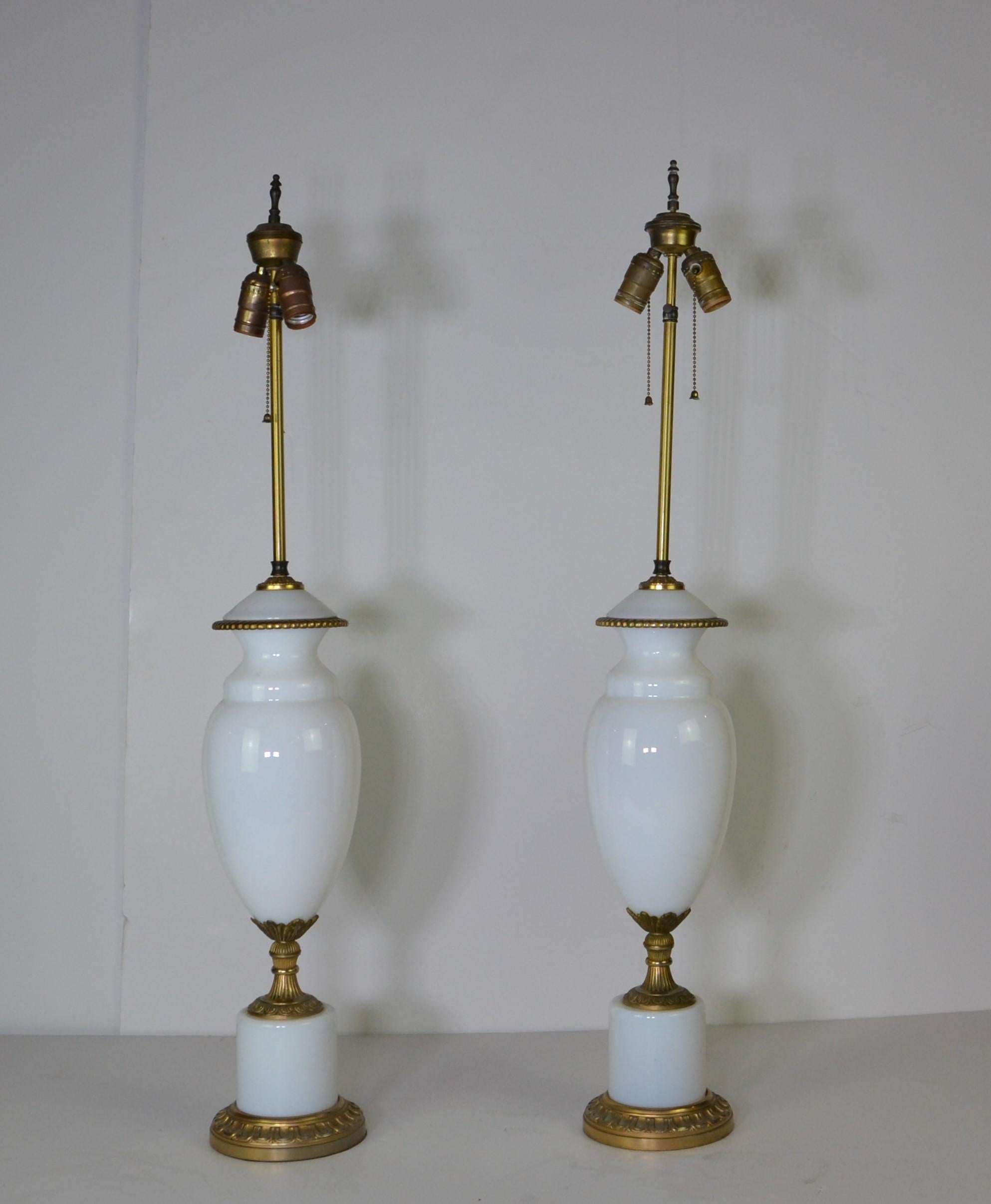 Paar europäische Urnenlampen aus weißem Glas. Der Sockel und die goldenen Details sind aus Messing.