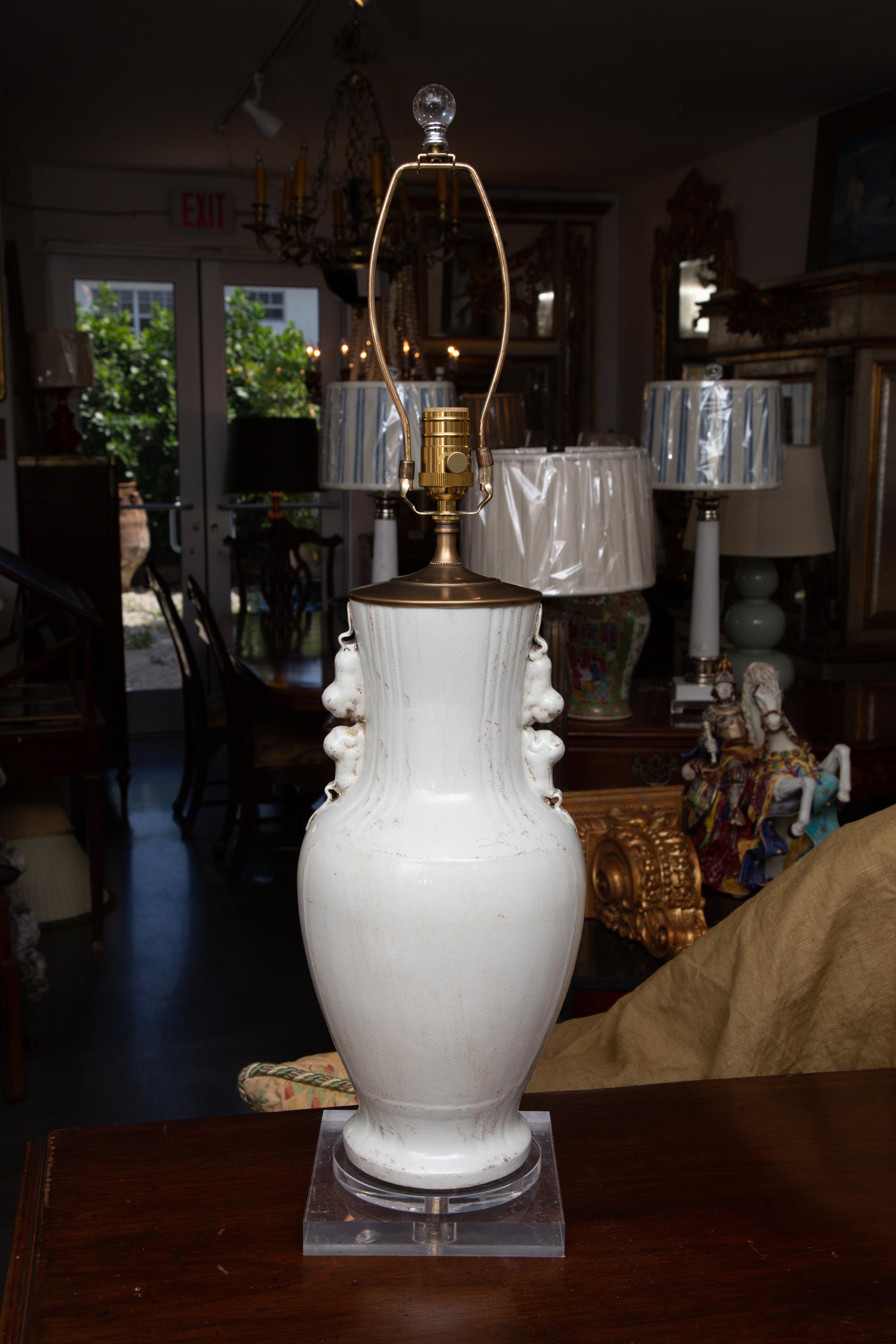 This is a pair of Asian hand made glazed white ceramic vases converted to table lamps. The vases are mounted on a plexiglass square base. 20th century.