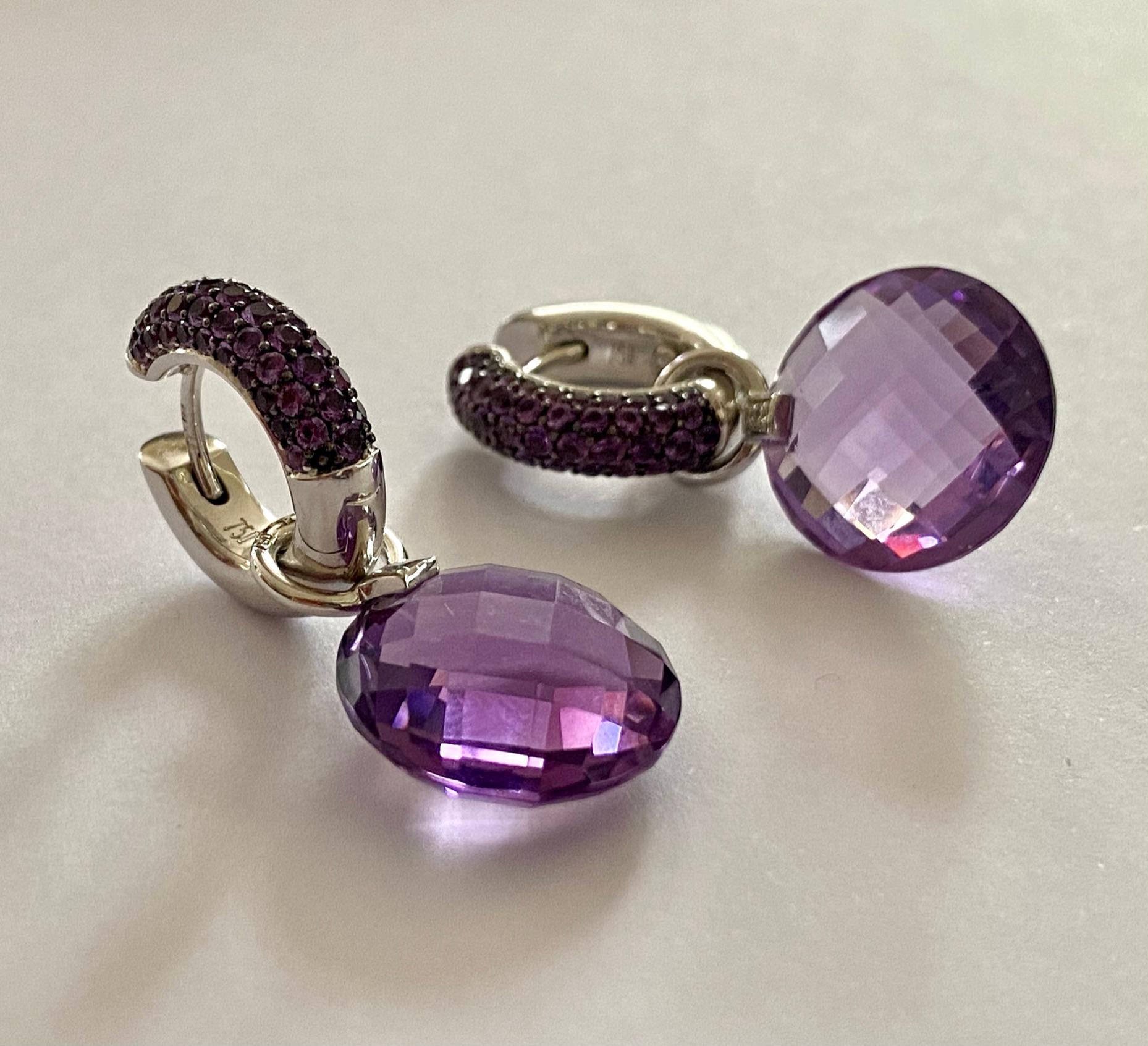 Eine  Paar Ohrringe aus 18 Karat Weißgold, besetzt mit zwei natürlichen Amethysten im Schachbrettschliff und 102 natürlichen Amethysten im Mischschliff sowie sechs  runde natürliche Diamanten im Brillantschliff an den Seiten
Gesamtgewicht des