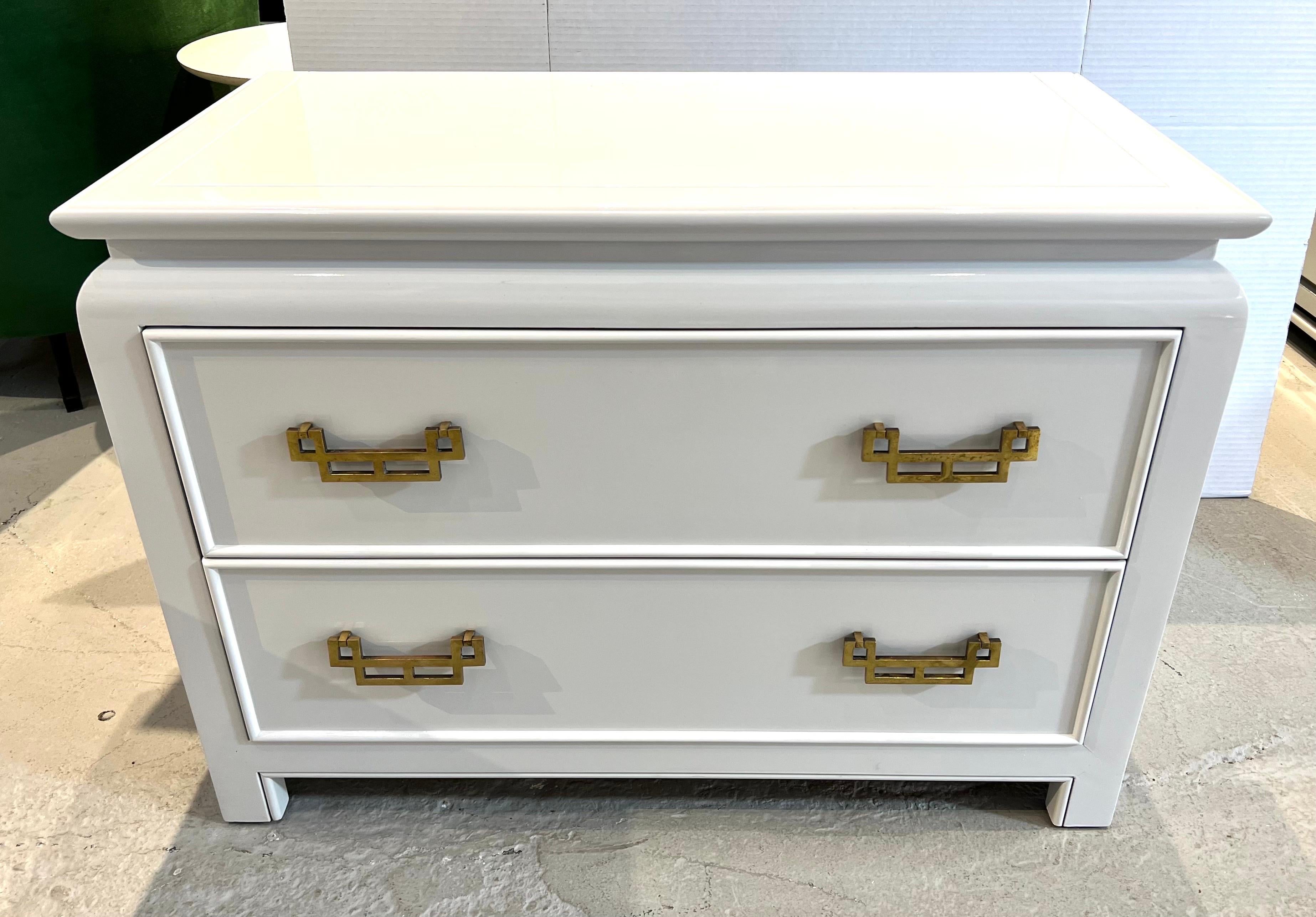 Pair of matching chinoiserie style nightstands have recently been lacquered in a crisp white. Original brass hardware. By Century Furniture.