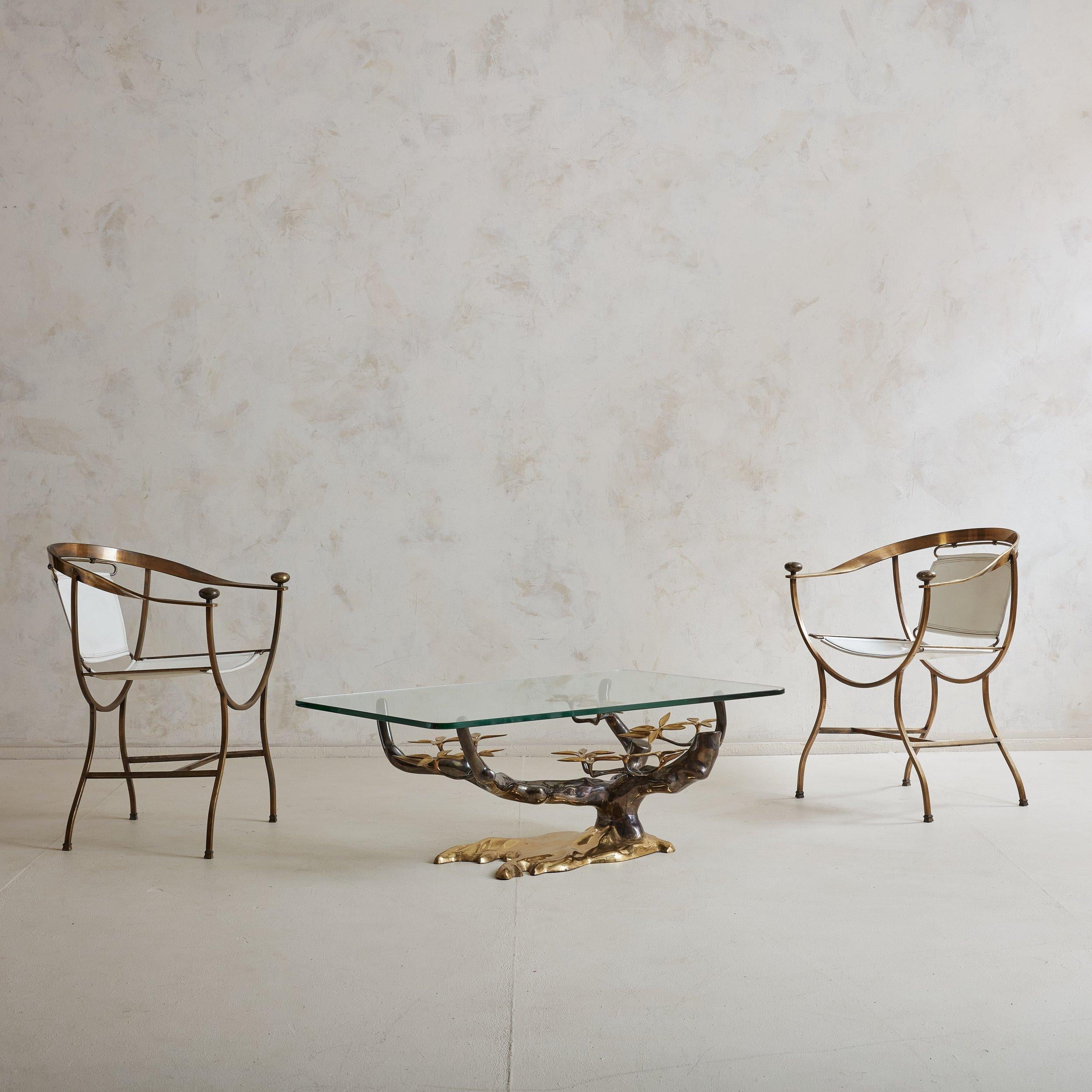A pair of rare white leather and brass ‘Pompeii’ armchairs designed by Italian designer Alberto Orlandi. These Neoclassical chairs feature elegant curved backrests and white leather sling seats. The brass feet and arm finial details add to the