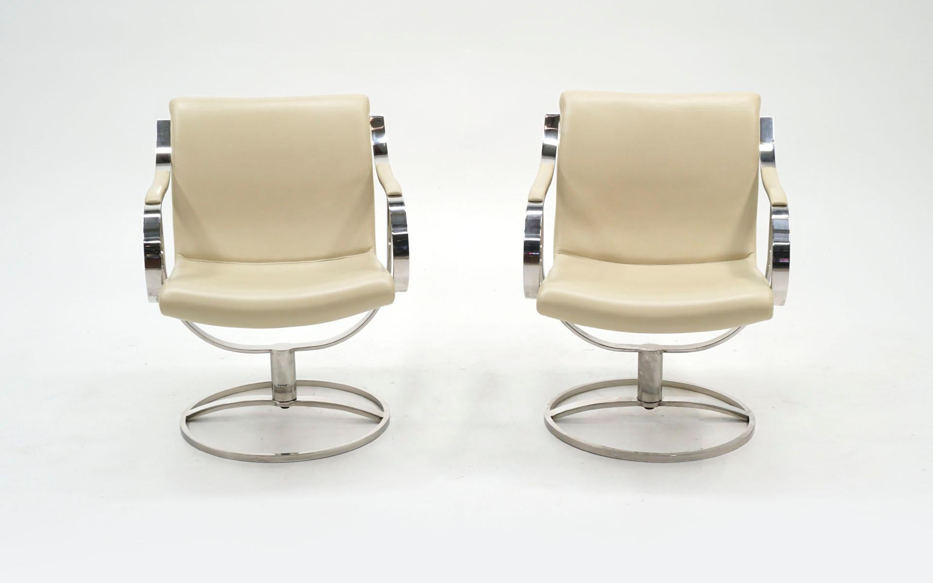 Pair of swivel armchairs designed by Gardner Leaver for Steelcase.  Ivory leather with frames of heavy polished stainless steel, not chrome.  Both chairs are in very good to excellent condition showing little to no wear to the leather or to the