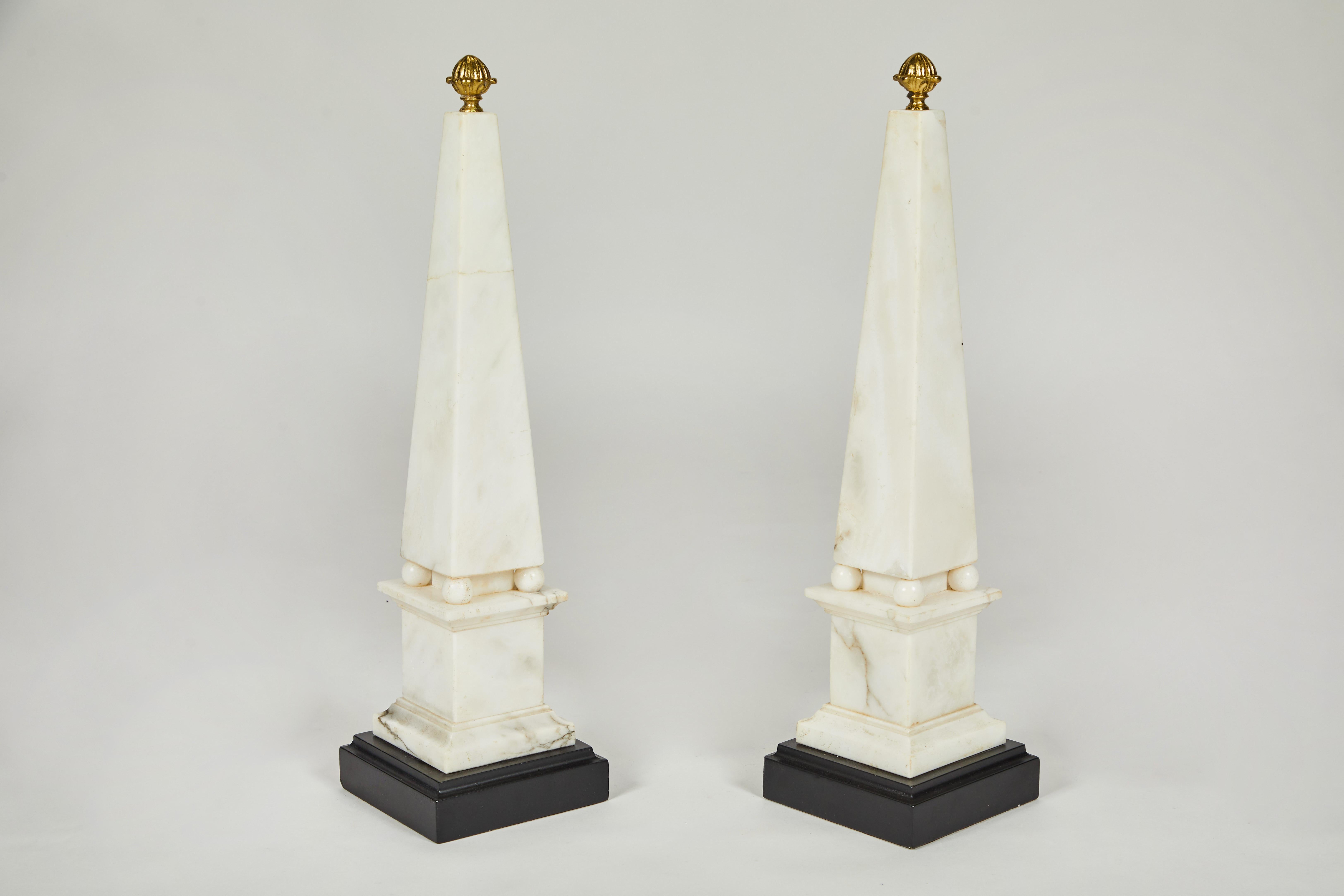 Pair of White Marble Obelisks on Painted Wood Bases with Brass Acorn Finials In Fair Condition For Sale In Los Angeles, CA