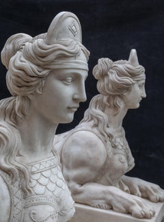 Pair of white marble sculptures depicting reclining sphinxes