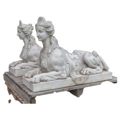 Pair of white marble sculptures depicting reclining sphinxes