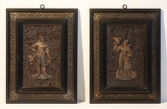 Paire de plaques en métal blanc et bronze doré représentant des personnages de 17e siècle