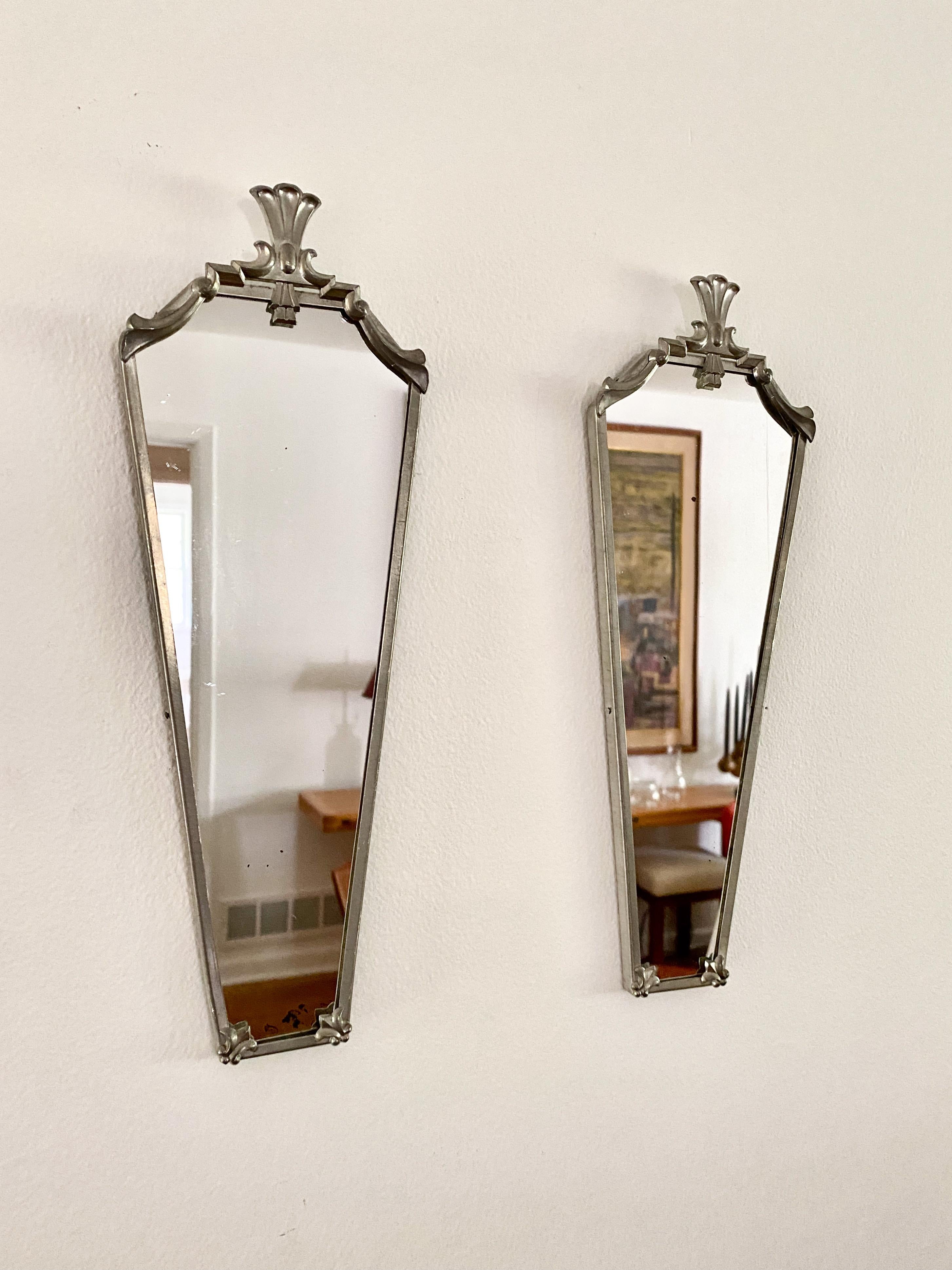 A pair of diminutive mirrors probably made in the 1920's - 1930's for Svenskt Tenn in Sweden.  The mirrors appear to made of a matte finish white / pewter type metal.  The mirrors are attributed to either Nils Fougstedt or Edvin Ollers and are in