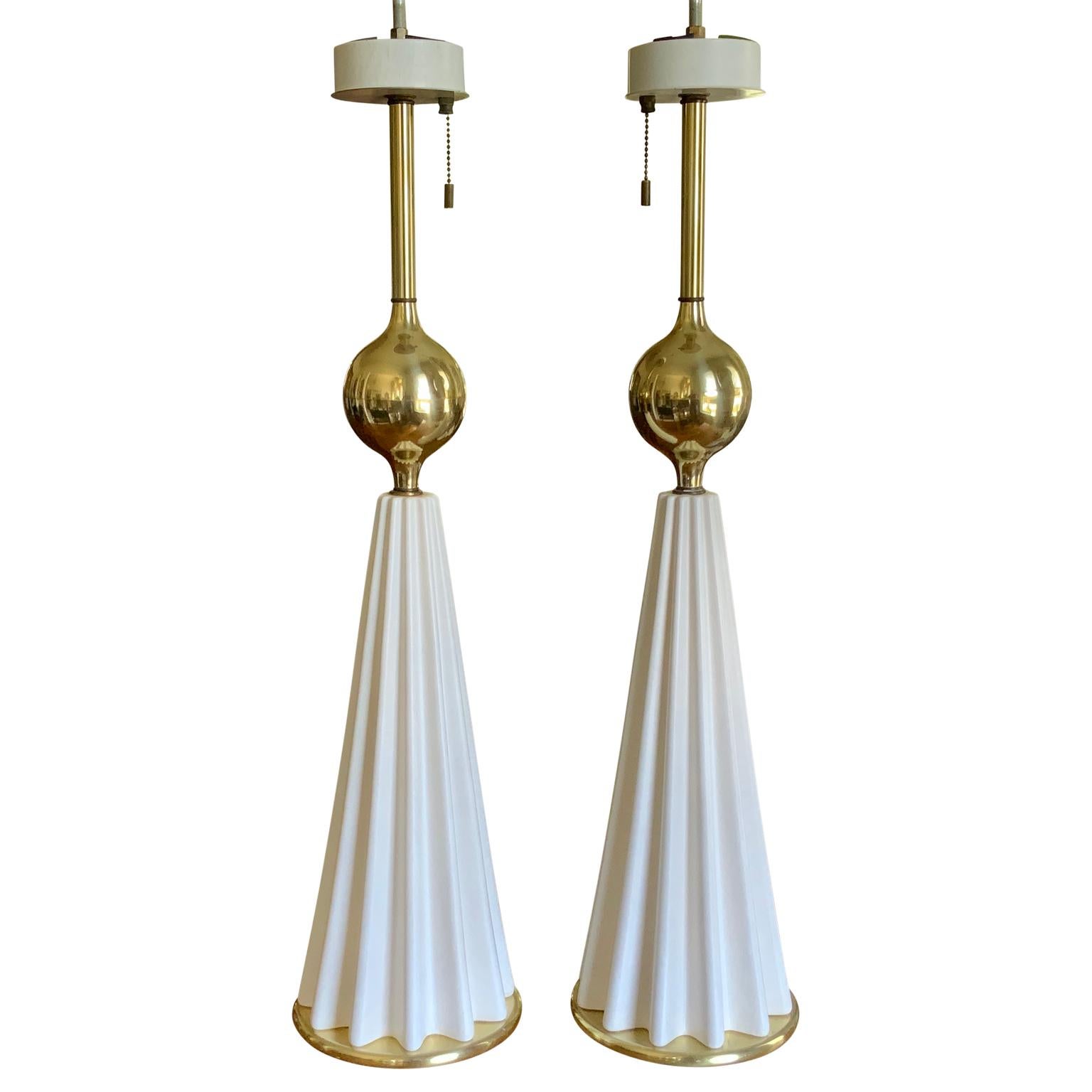 A pair of Mid-Century Modern Gerald Thurston table lamps for Lightolier
Brass ball and sculptural ribbed white ceramic on brass bases. Original brass finials. 3 sockets per lamp with original brass pull chains.