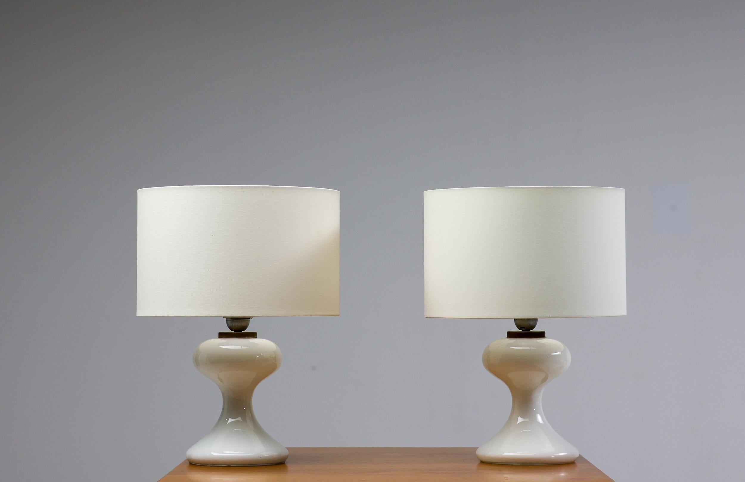 Tolles Paar weißer Tischlampen aus mundgeblasenem Glas mit weißem Leinenschirm, 1968 von Ingo Maurer für seine Firma M-Design entworfen. Ein sehr elegantes Design, das einem Raum trotz des strengen, modernen Erscheinungsbildes eine warme Atmosphäre