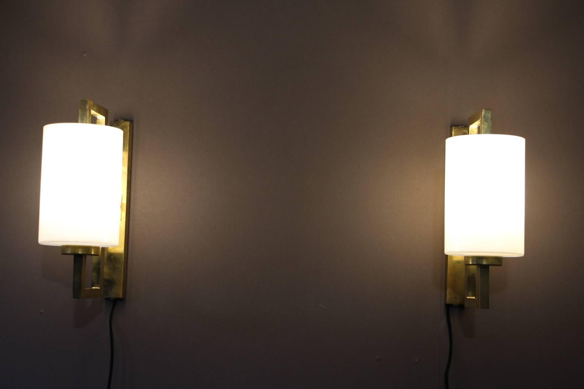 Exquisite pair of geometric brass structure holding iridescent and pearly Murano glass cylinder.
Their color turn to white when the light is on.
Very elegant shape and colors.They are wired for the US and work with 110 or 220 Volts.Please note that