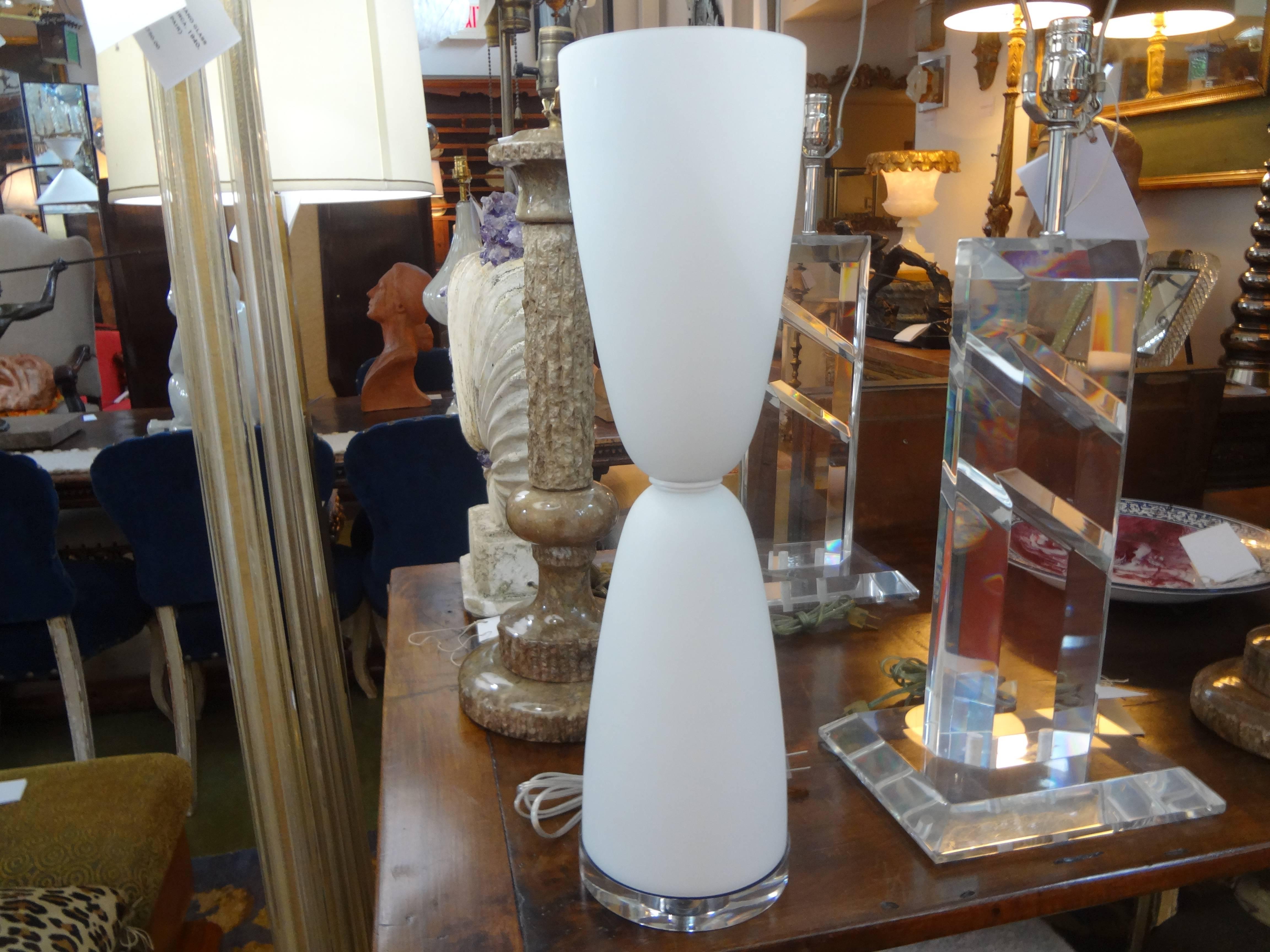 Unusual pair of frosted white murano glass lamps on Lucite bases. This stunning pair of Mid-Century Modern Italian hourglass shaped lamps have been newly wired for the U.S. market with new porcelain sockets and inline switches.
This pair of Murano