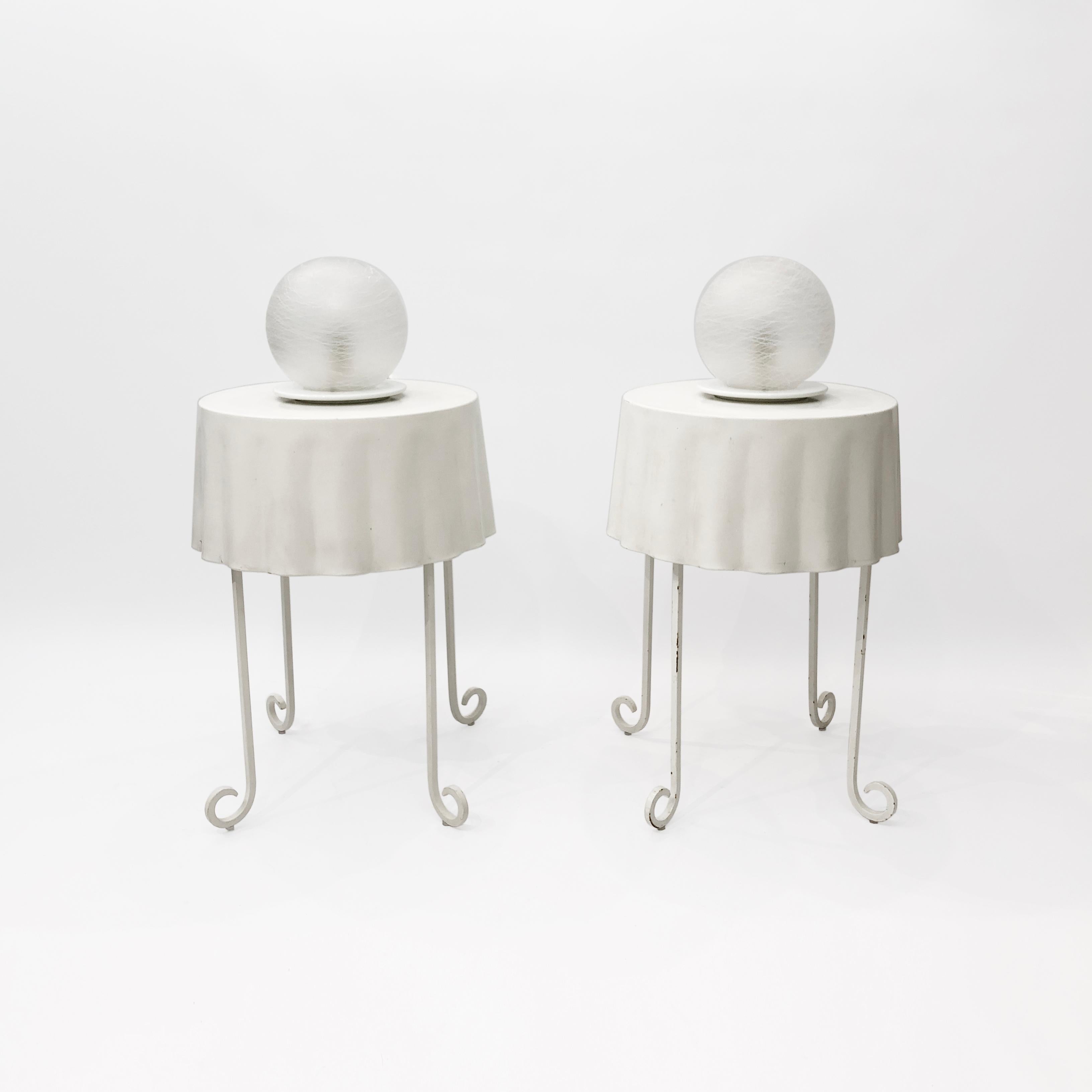 A pair of white, spherical murano glass table lamps, originating from Italy in the 1970s. Each lamp consists of a frosted glass orb sat on top of a white powder-coated metal base. The glass has been handblown, and features a frosted, fibrous