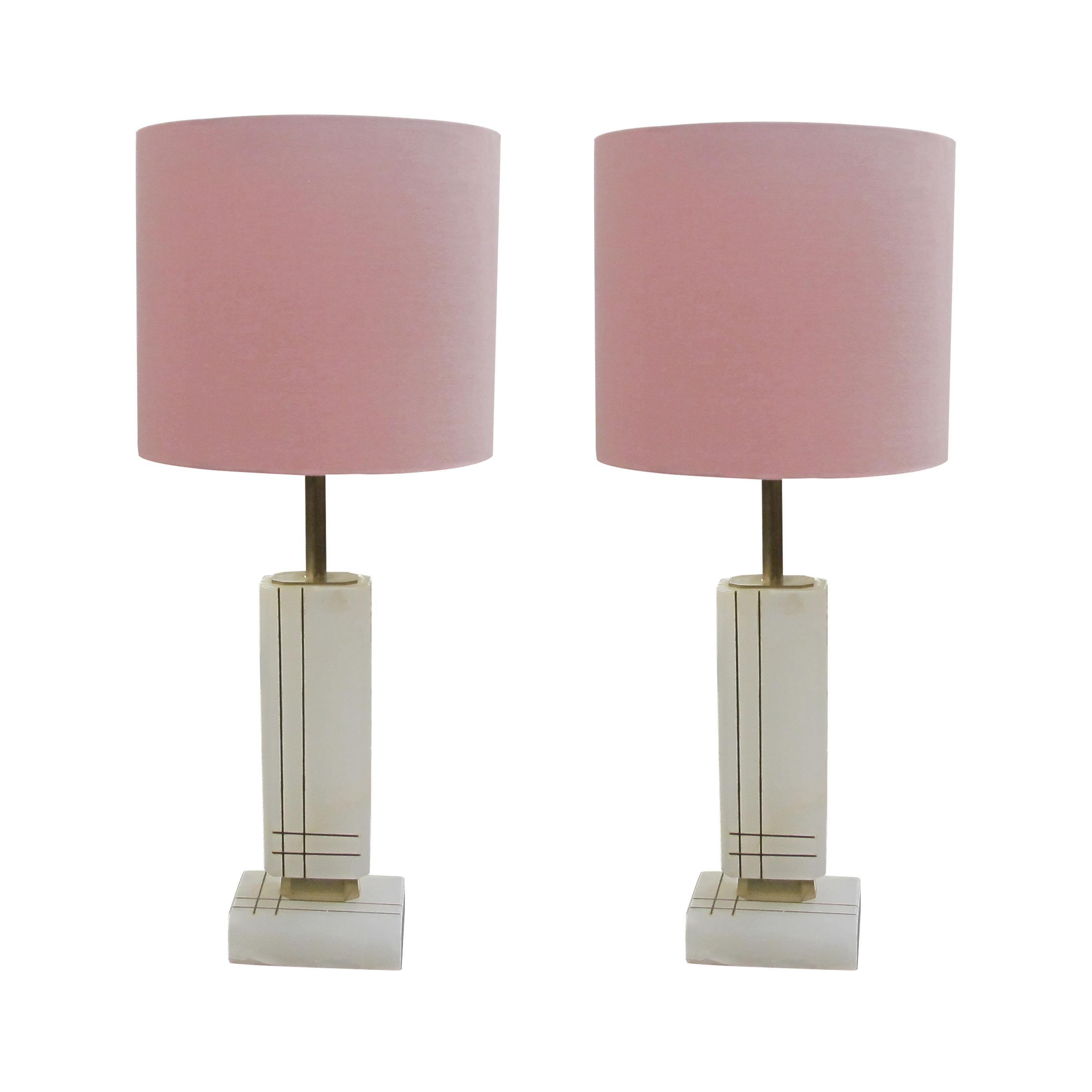 Elegant pair of table lamps, crafted from white onyx with smooth surfaces and embellished with gold engraved straight lines. The natural variations in the onyx add depth and character, making each piece truly unique. The edges of the onyx have been
