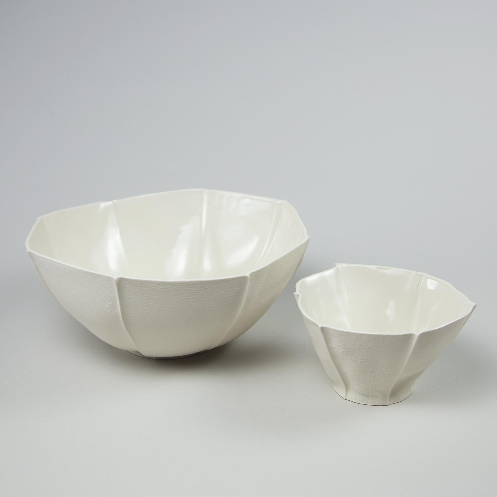 A pair of tactile and organic shaped porcelain bowls with leather textured exterior surface and a smooth glazed interior. The Kawa Bowls are expressive and lively. With their fluid forms and pronounced leather texture, they demonstrate the unique