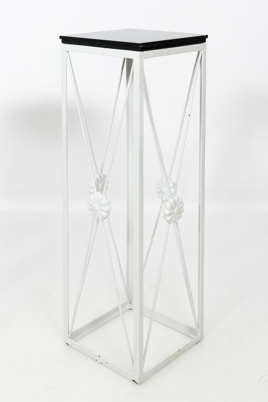 Pair of white painted Iron plant stands with black marble tops and flower latticework medallions, circa 1990.
 