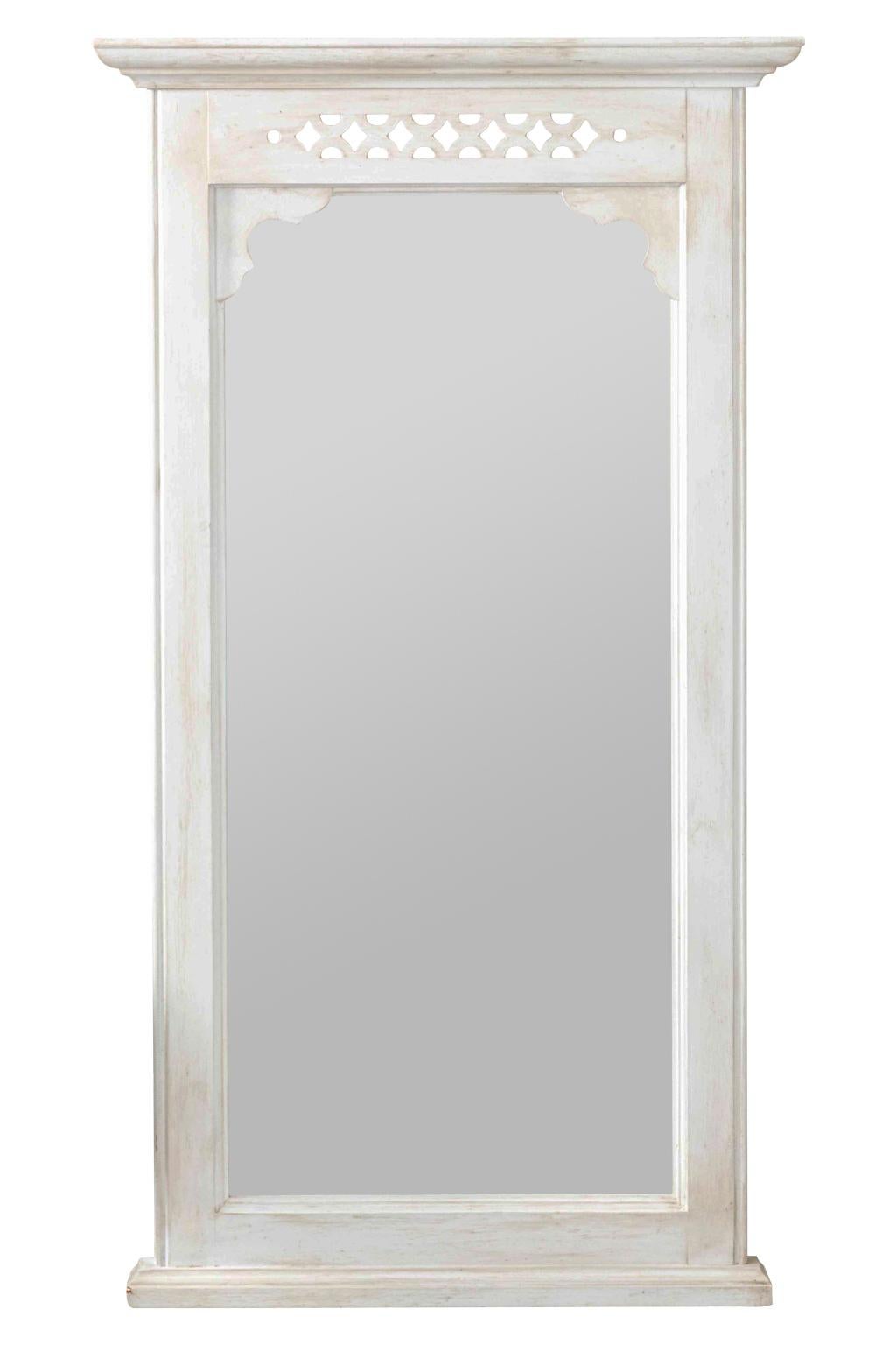 Pair of white painted wall mirrors in wood with pierced geometric crest and molded details, circa 1970s. Please note of wear consistent with age including minor wear to paint. Made in the United States.