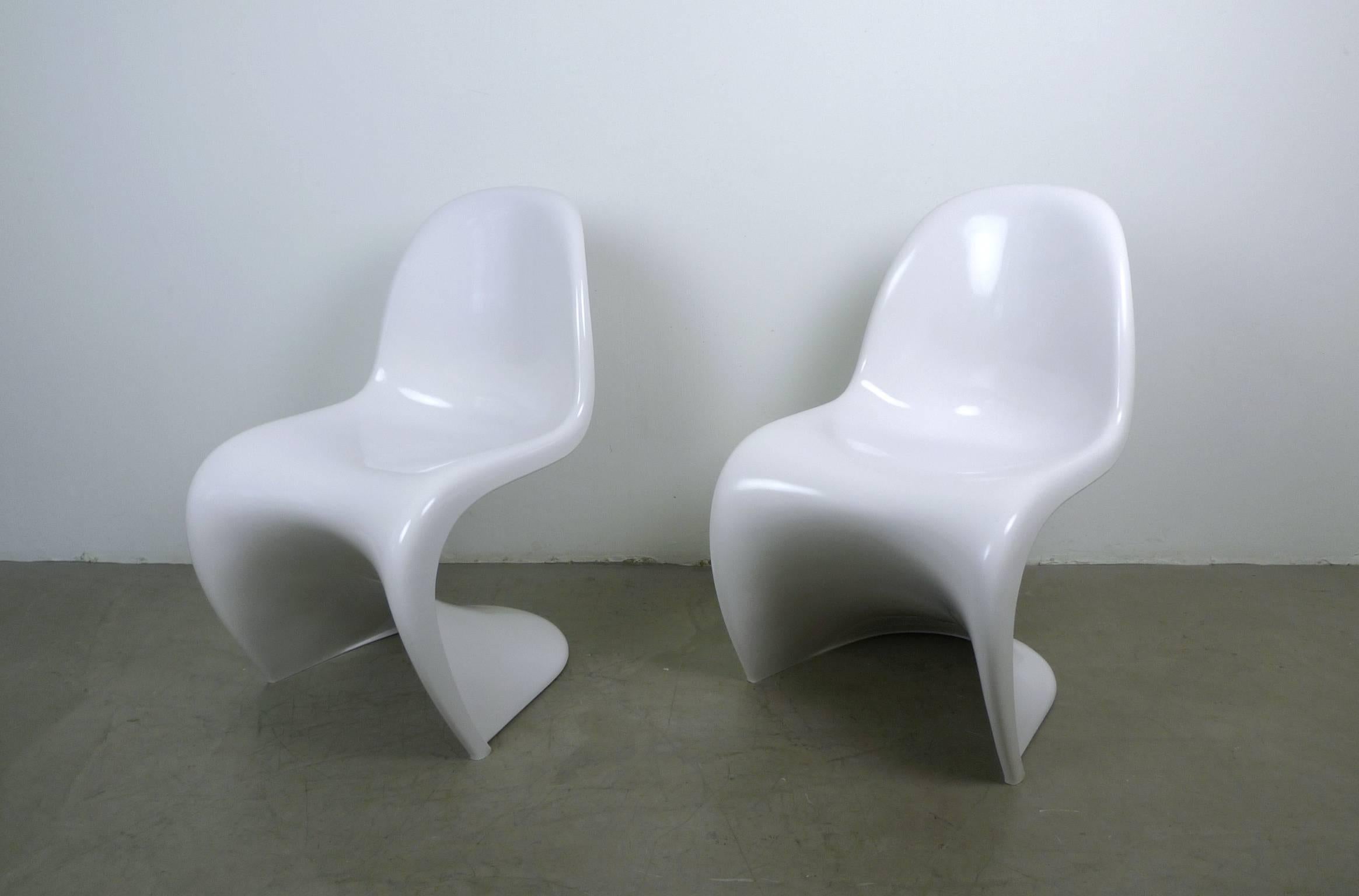 This set of two Panton chairs is made of white colored thermoplastic polystyrene and was produced in 1971 and 1972 by Fehlbaum in Germany under license from Herman Miller. The pair belongs to the third production series (1971-1979) and has