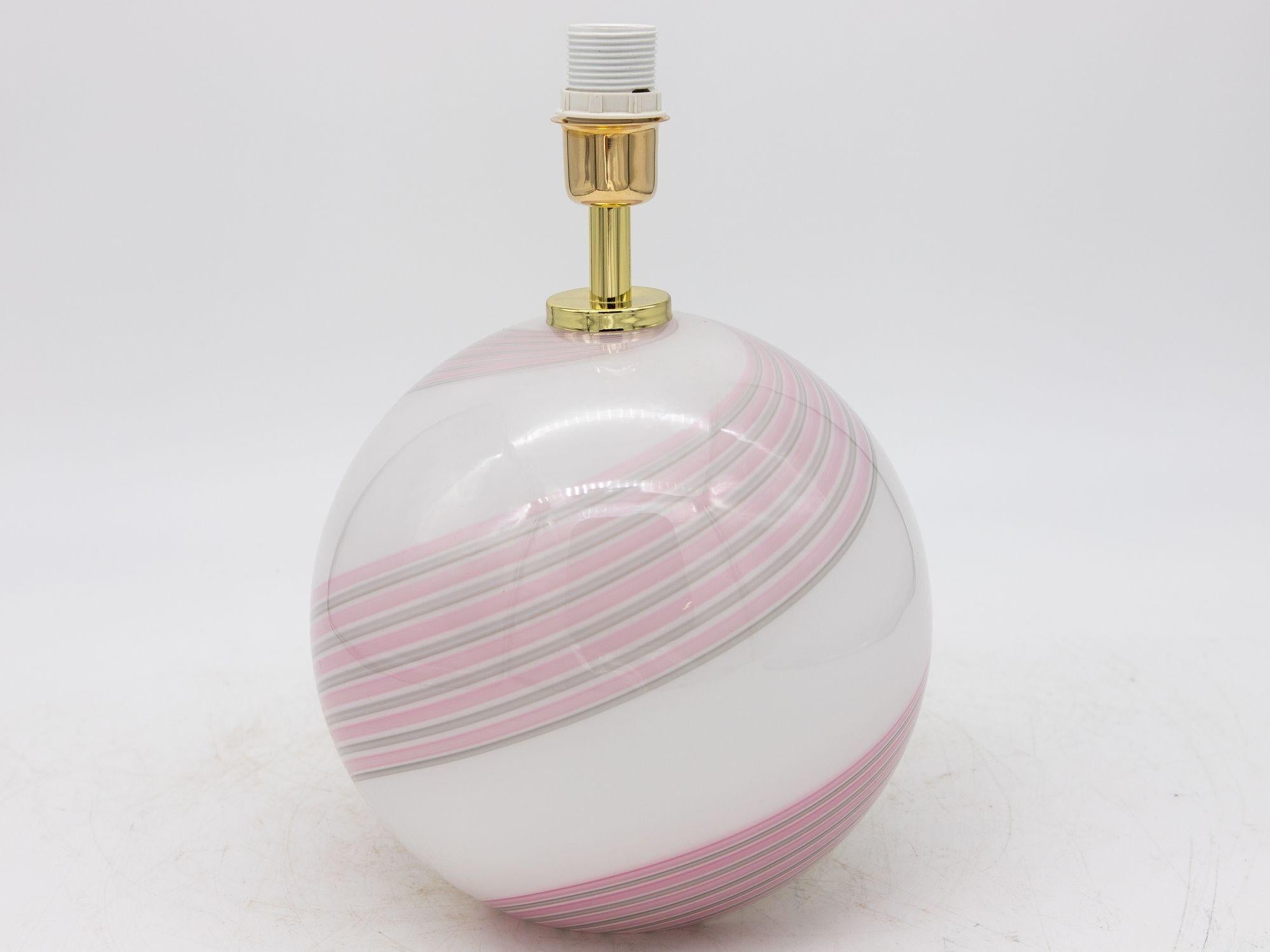 This pair of 21st-century Italian Murano glass table lamps exudes contemporary elegance with a touch of classic charm. Each lamp features a pink and gray swirl pattern gracefully overlaying a white glass globe, creating a mesmerizing visual effect.