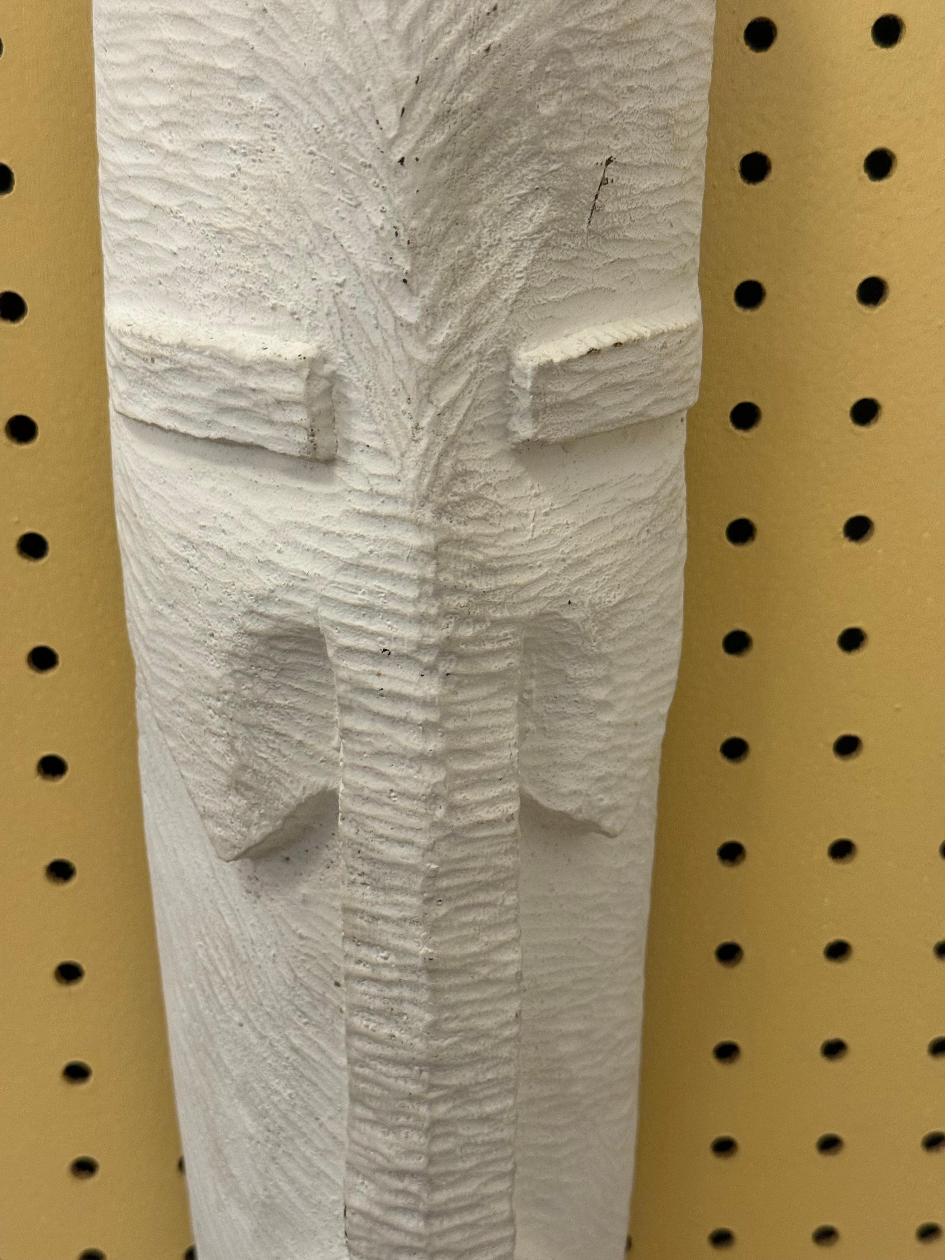 A pair of modern sculptural wall masks in textured white composite. One features geometric carved patterns, while the other incorporates abstract leaf motifs, combining organic forms with minimalist modern design. Each mask is signed MEXICO on the