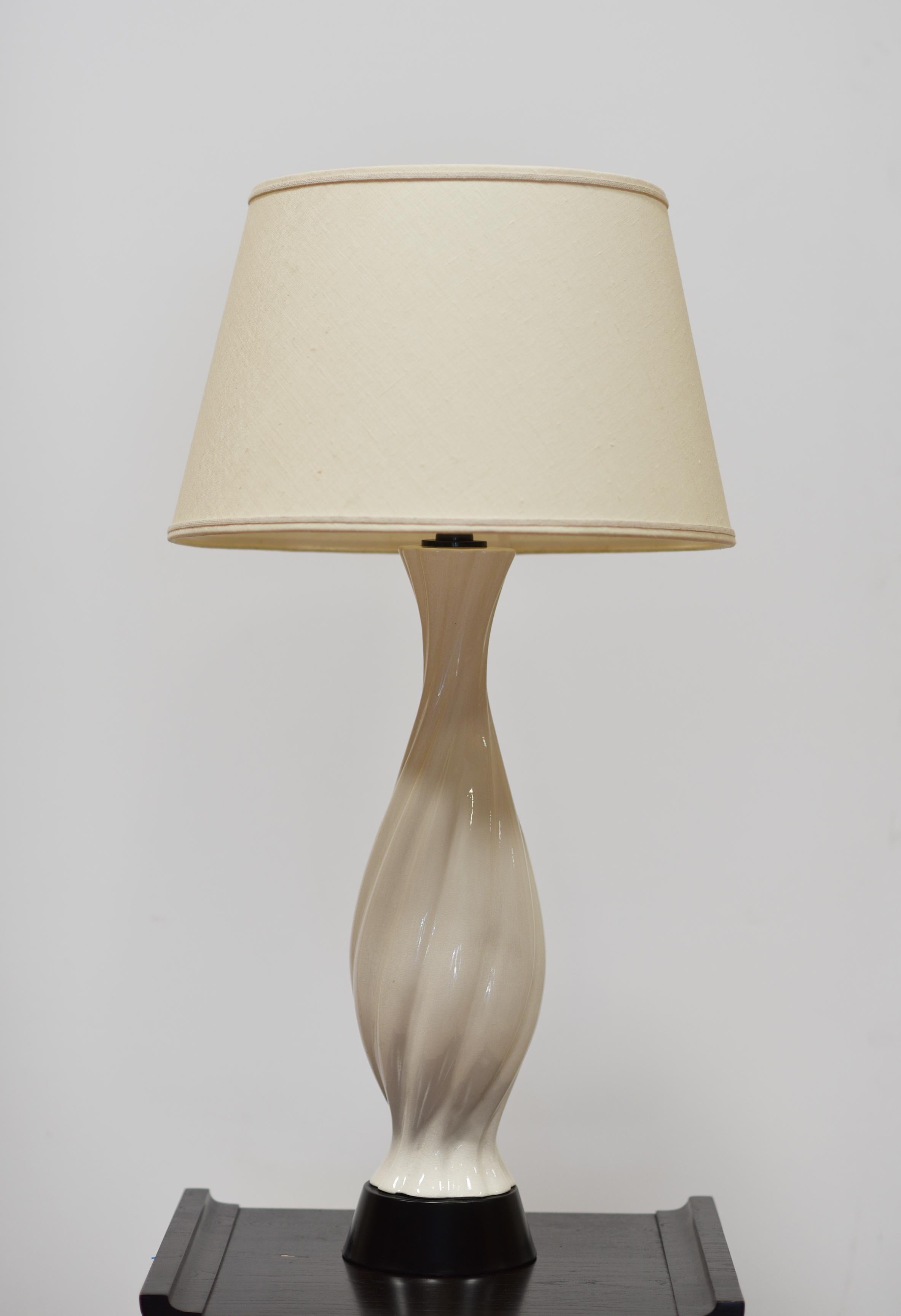 Paire de lampes de table en forme de balustre en porcelaine blanche du milieu du siècle dernier, vers 1950. Ces formes idéales sont élevées sur des bases en métal ébonisé avec une fine craquelure à la glaçure.