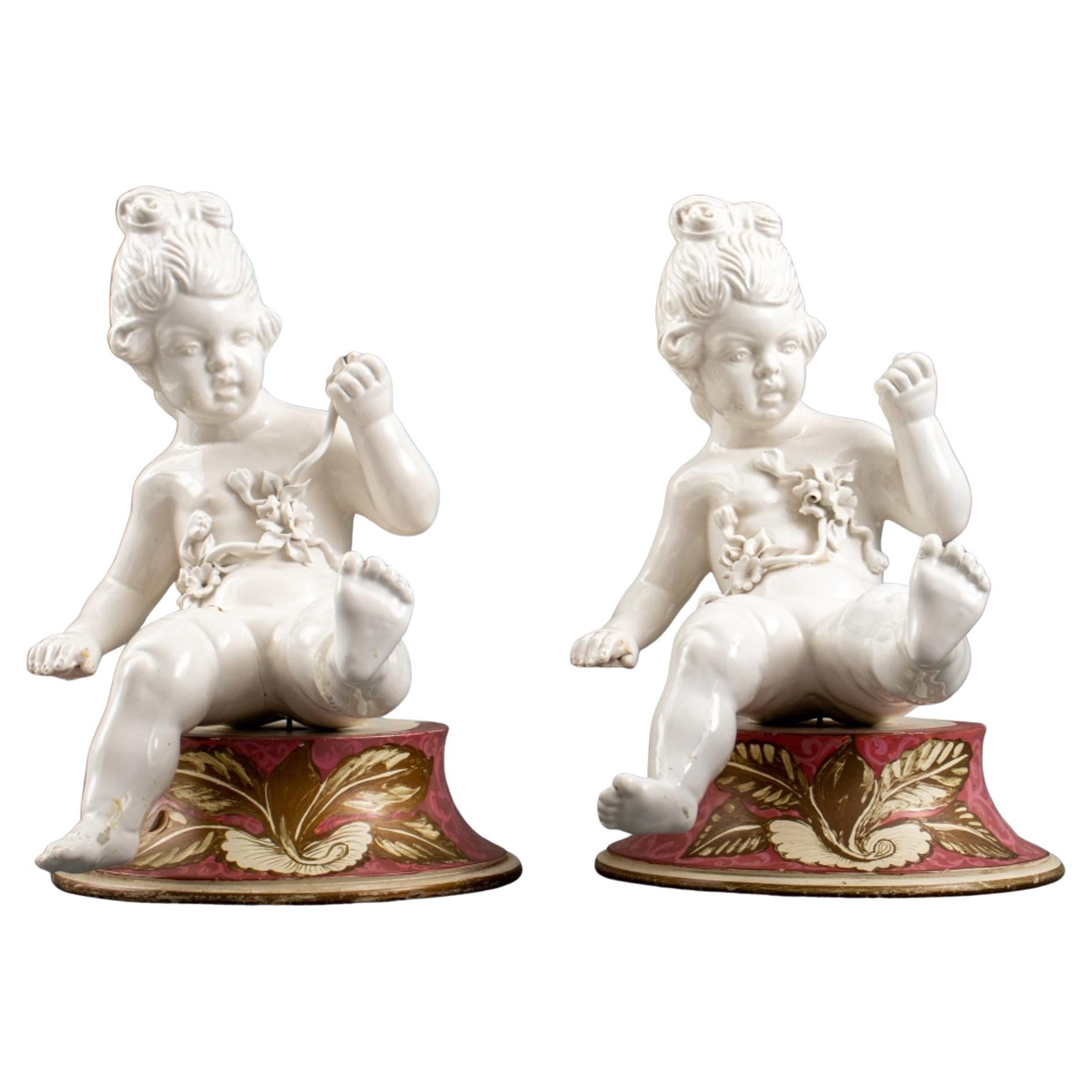 Pair of White Porcelain Cherub Putti Sculptures For Sale