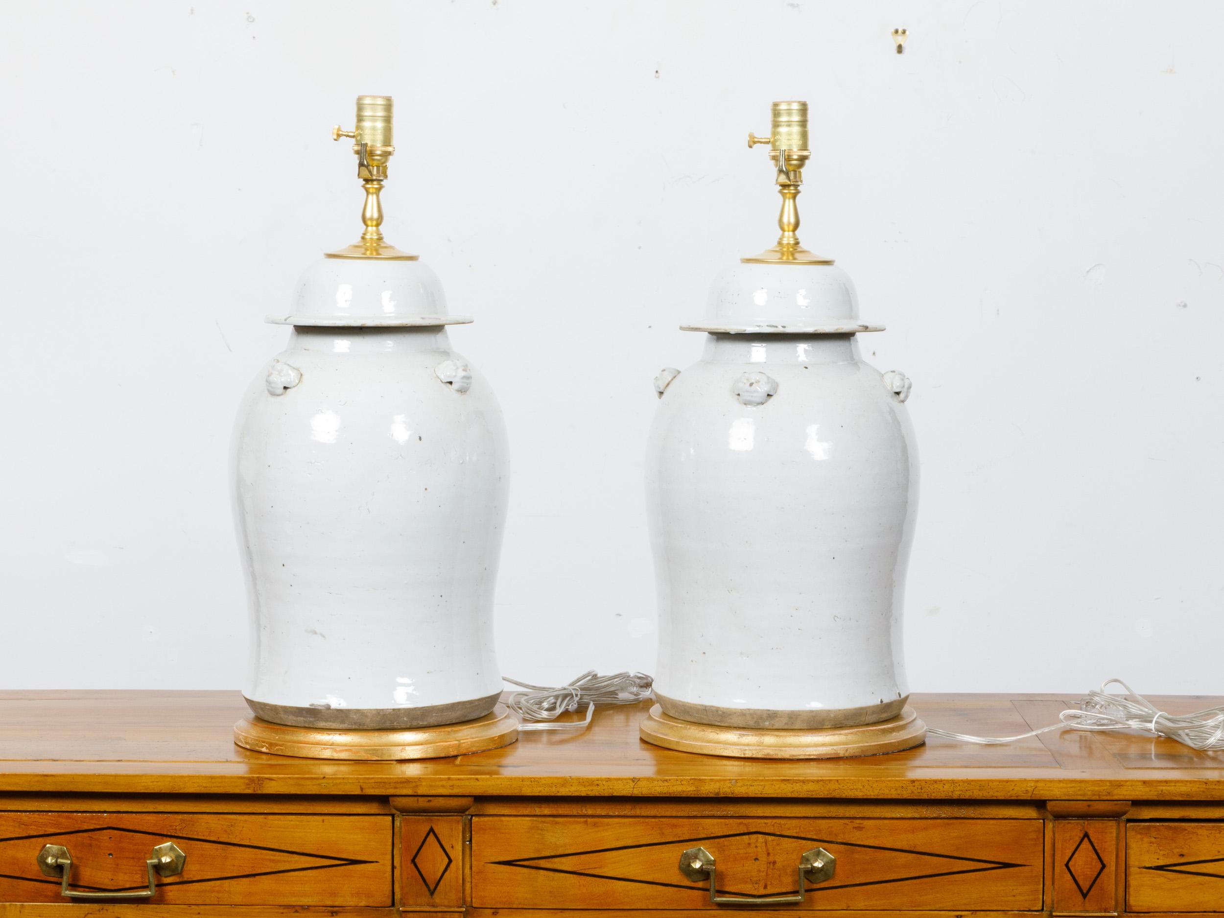 20th Century Pair of White Porcelain Lidded Urns Made into US-Wired Table Lamps on Gilt Bases For Sale